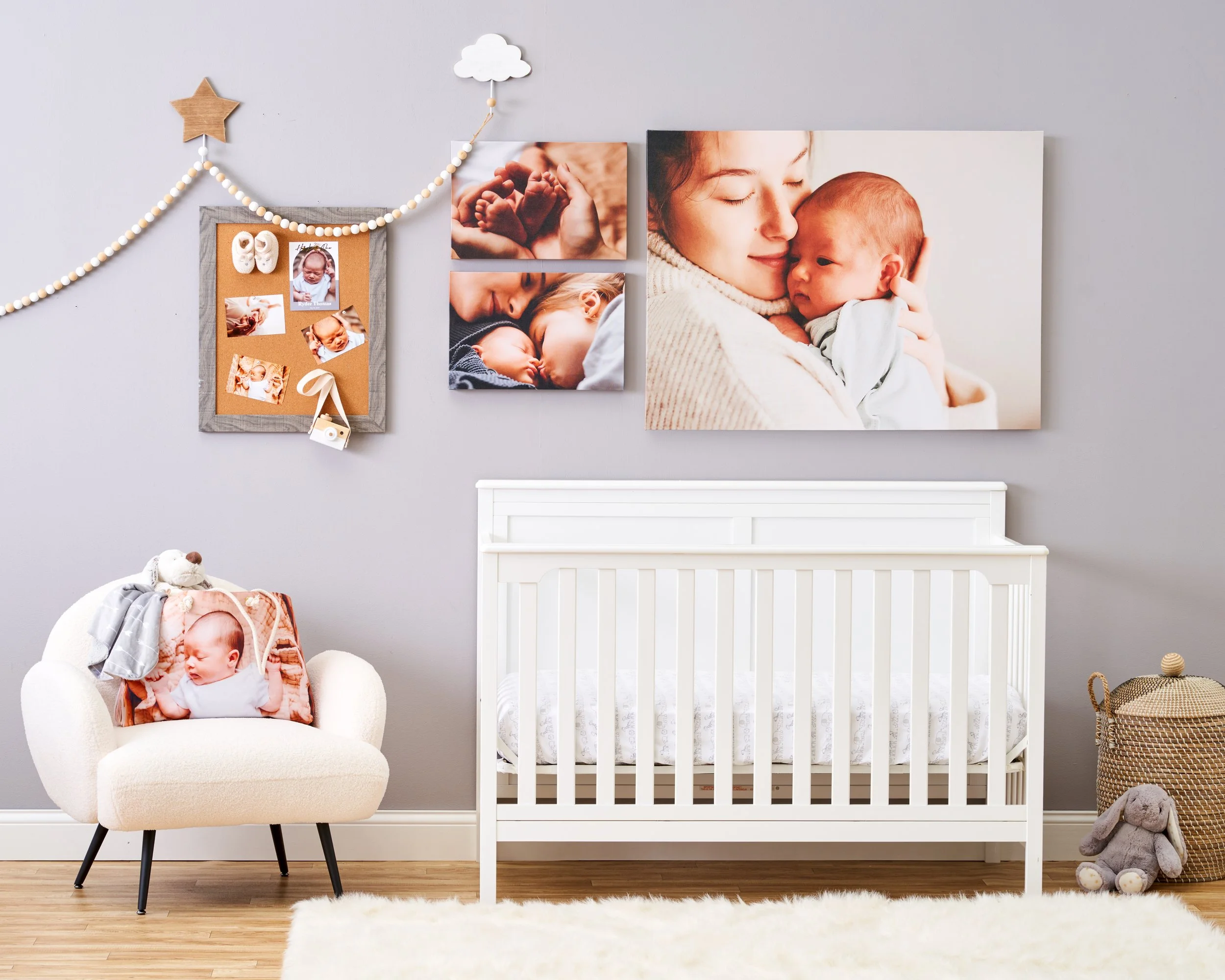 Nursery with a white crib, a beige armchair with a baby blanket and stuffed animal, photos of mother and baby on the wall, and a woven basket with a stuffed bunny.