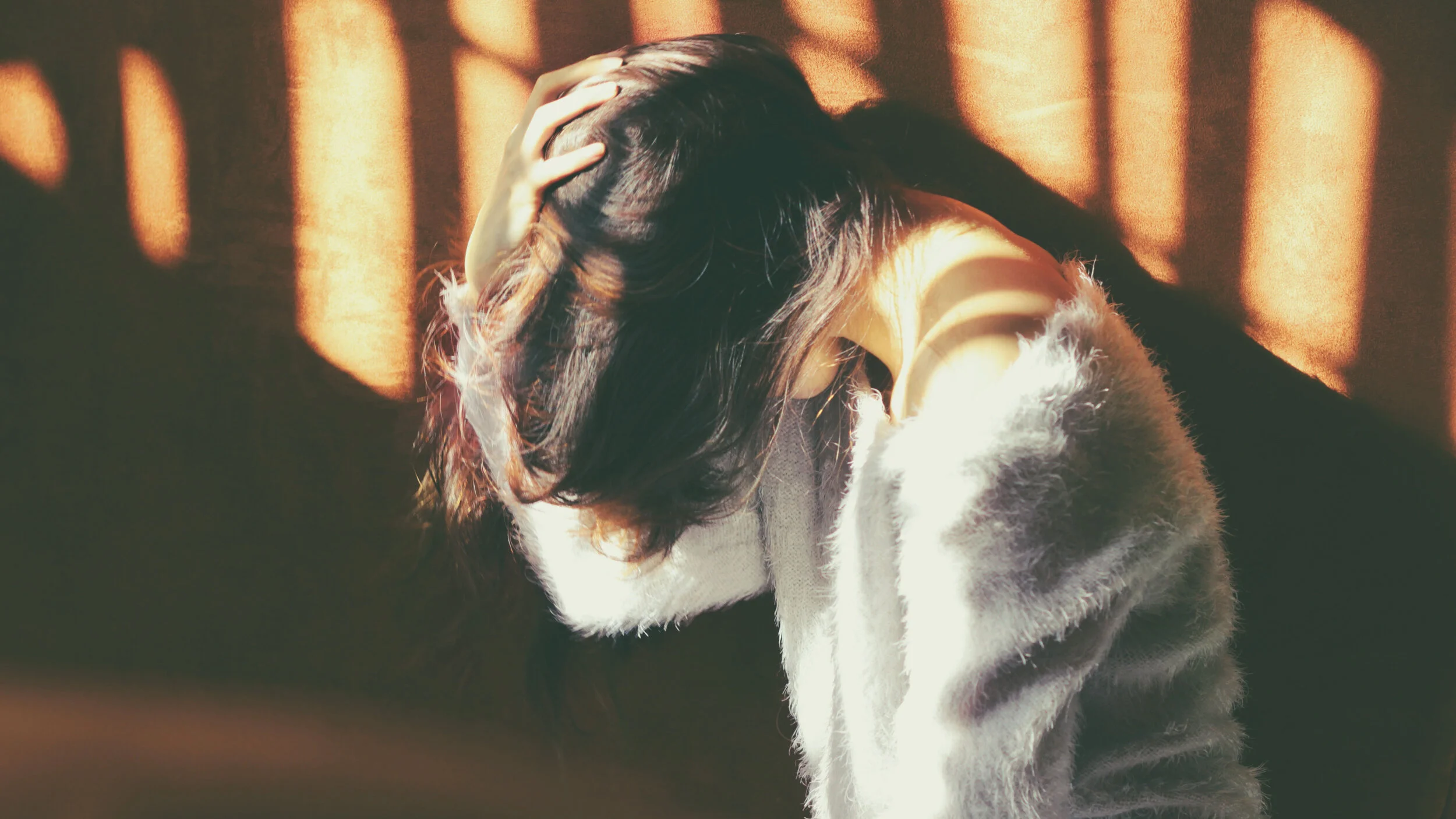 Woman holding her head in her hand