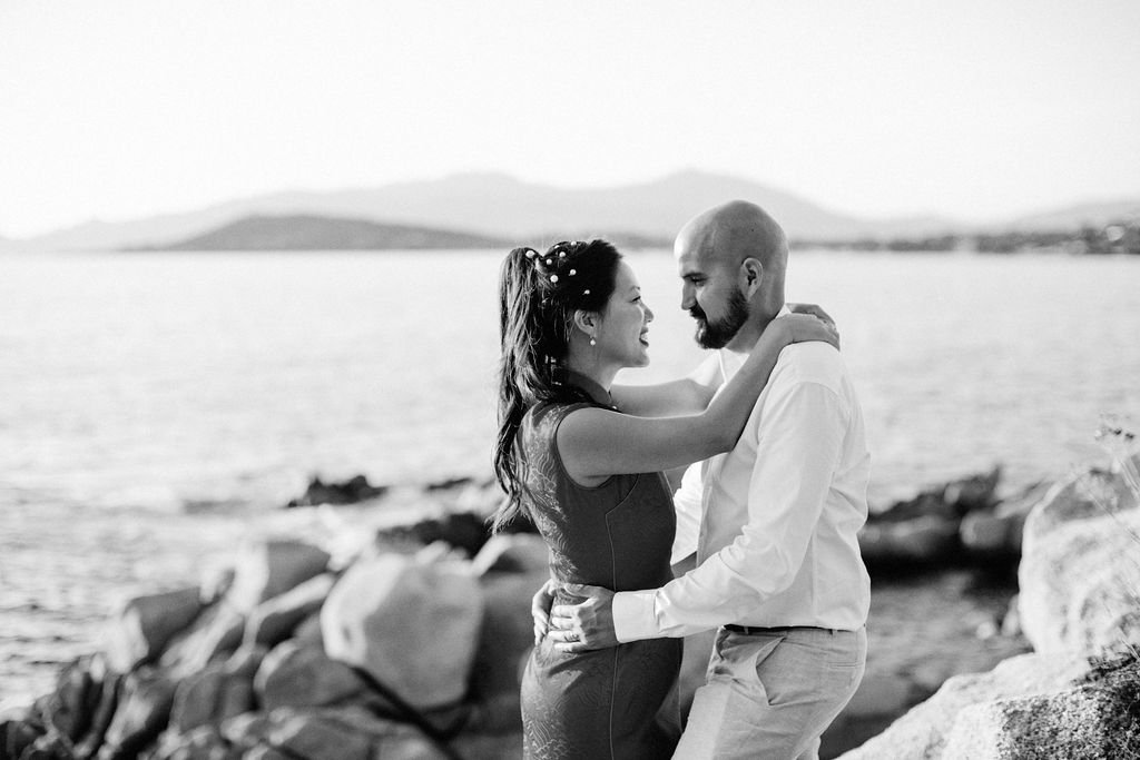 Un couple qui s'embrasse près de la mer, en noir et blanc.