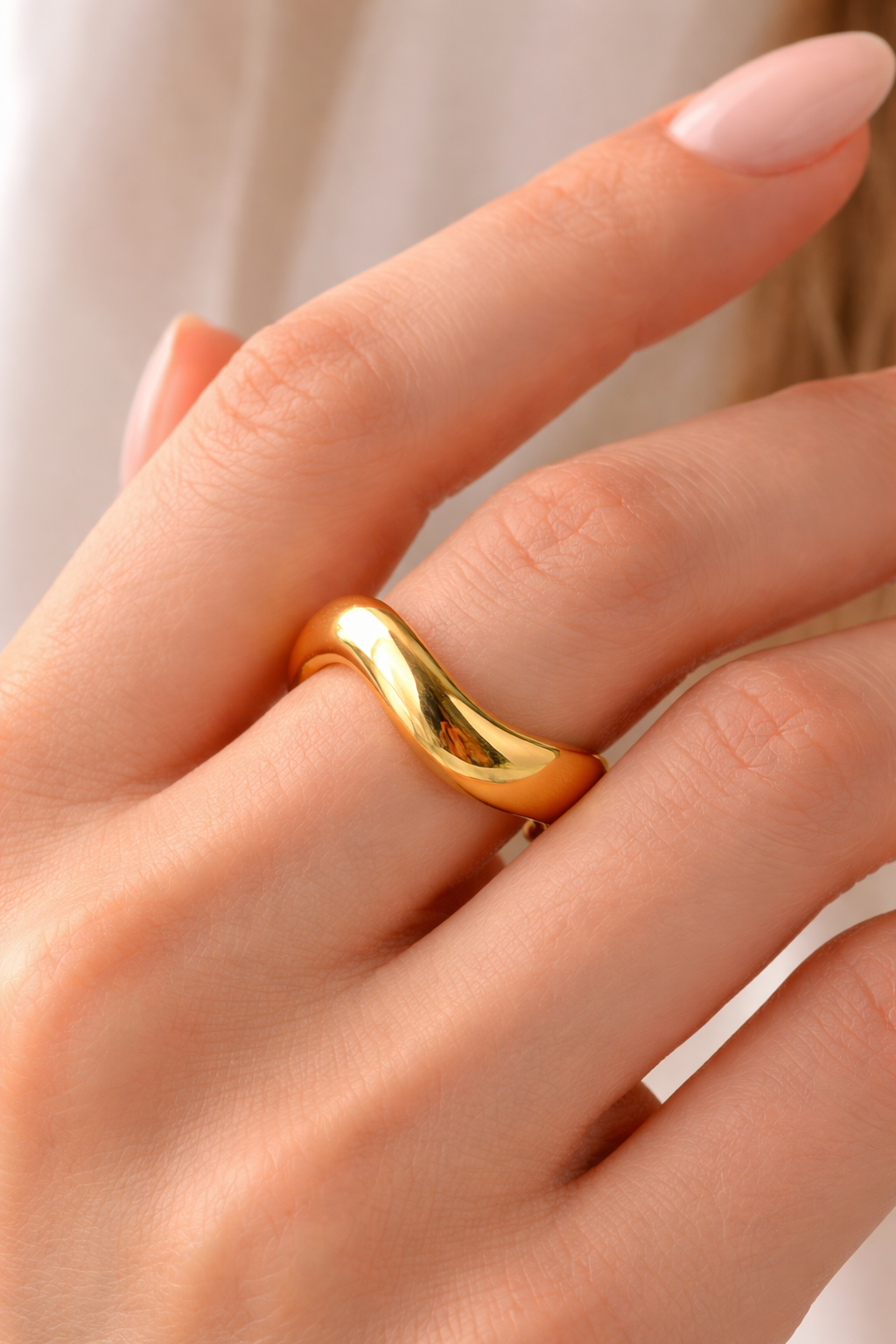 Elegant gold wave ring close-up.png