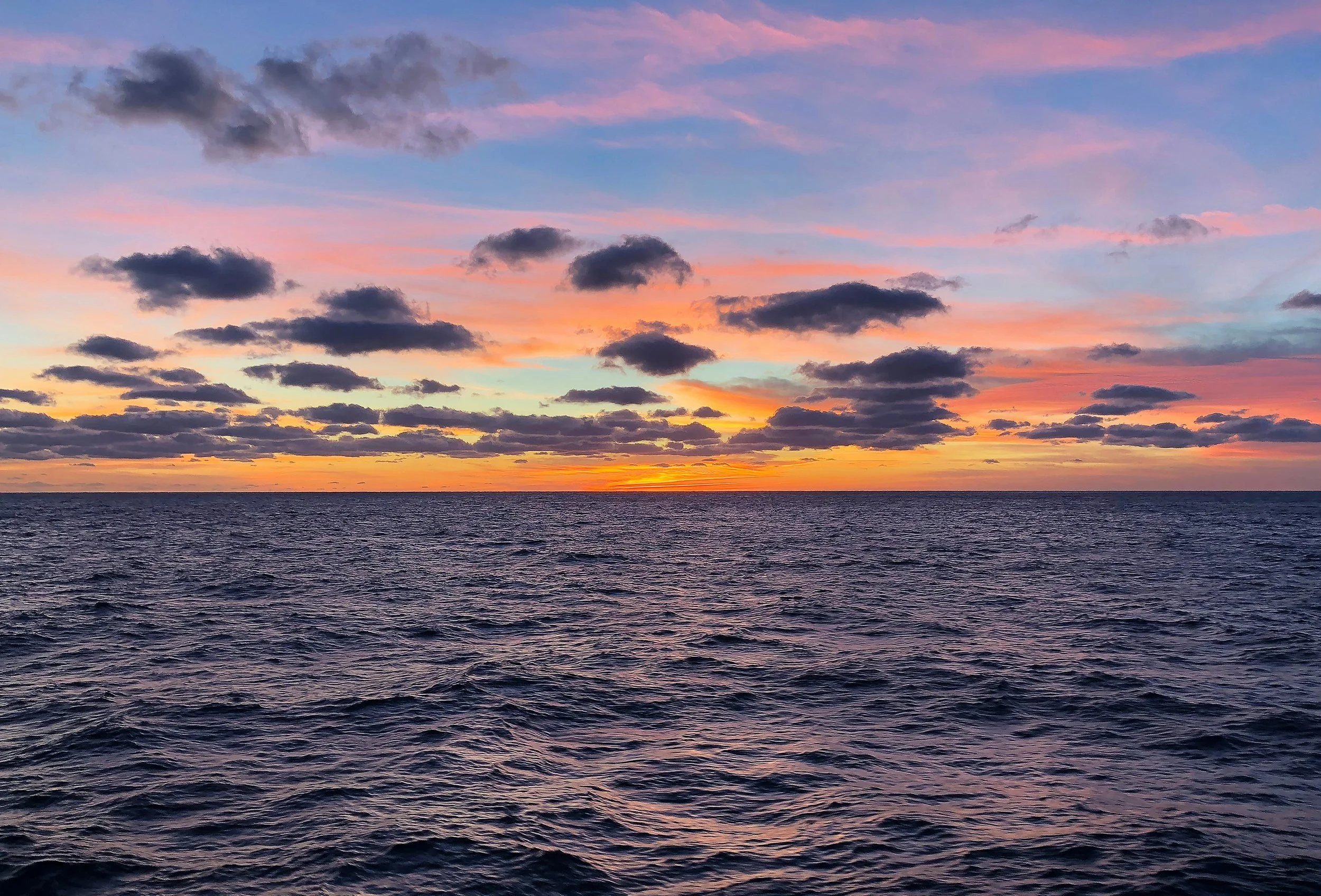 Sunset over the ocean with colorful clouds in the sky