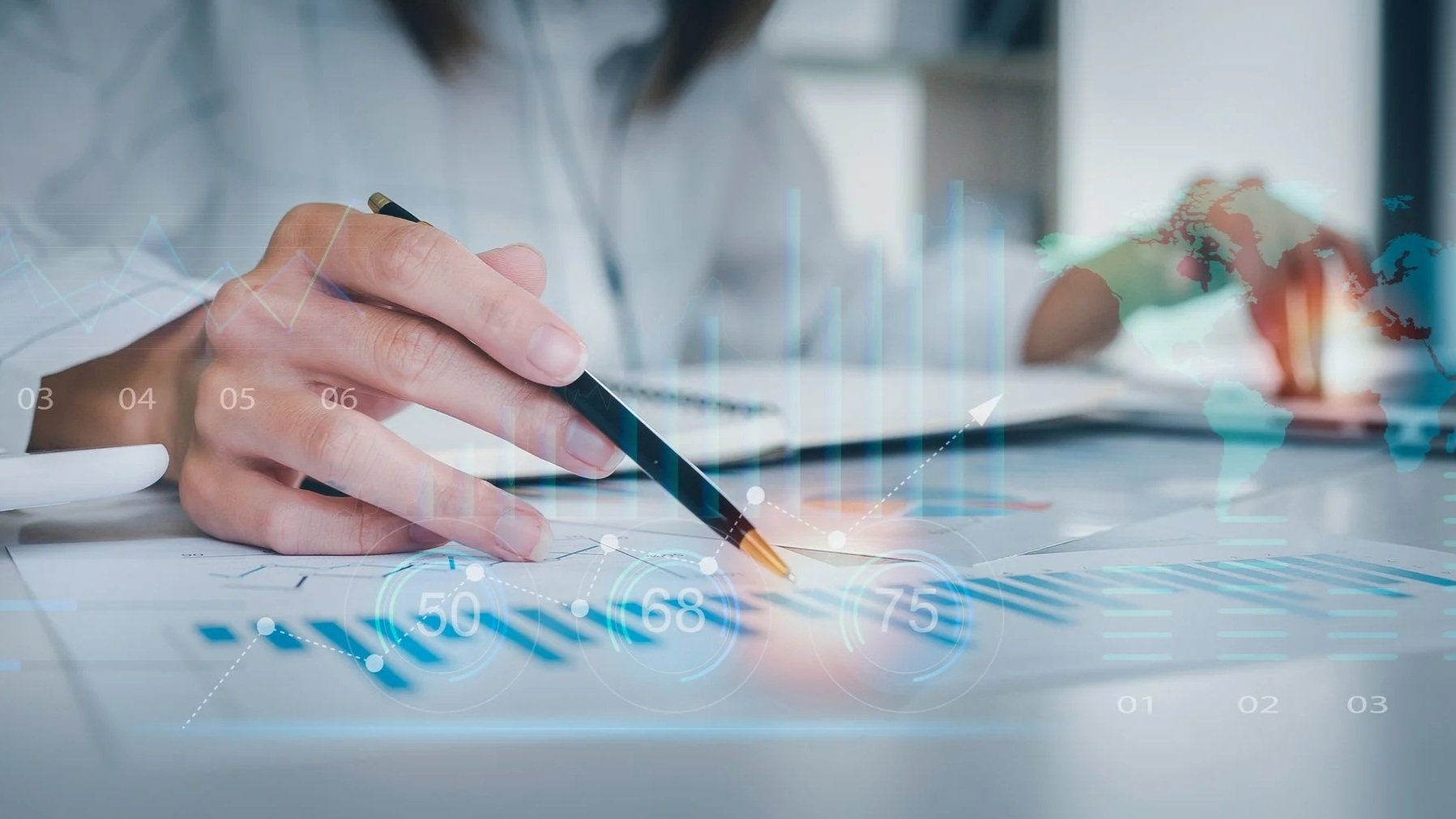 Close-up of a person's hand holding a pen, working on a paper with digital overlay of graphs, data points, and a world map.