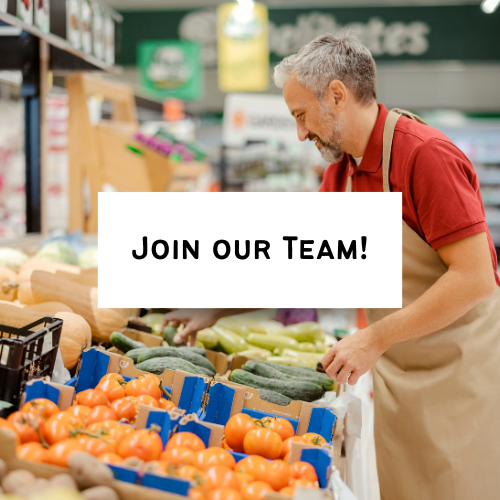A man shopping at a grocery store produce section, selecting vegetables with a sign saying 'Join Our Team!' in the foreground.