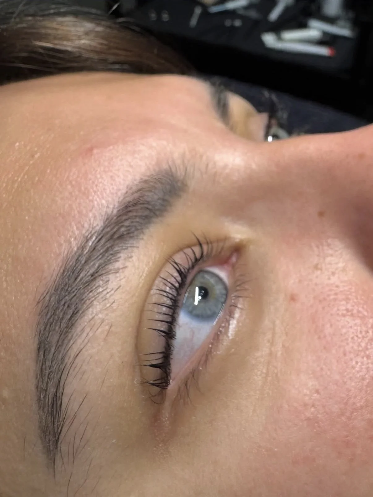 Close-up of a woman's eye showing well-groomed eyebrow, long eyelashes, and clear skin.