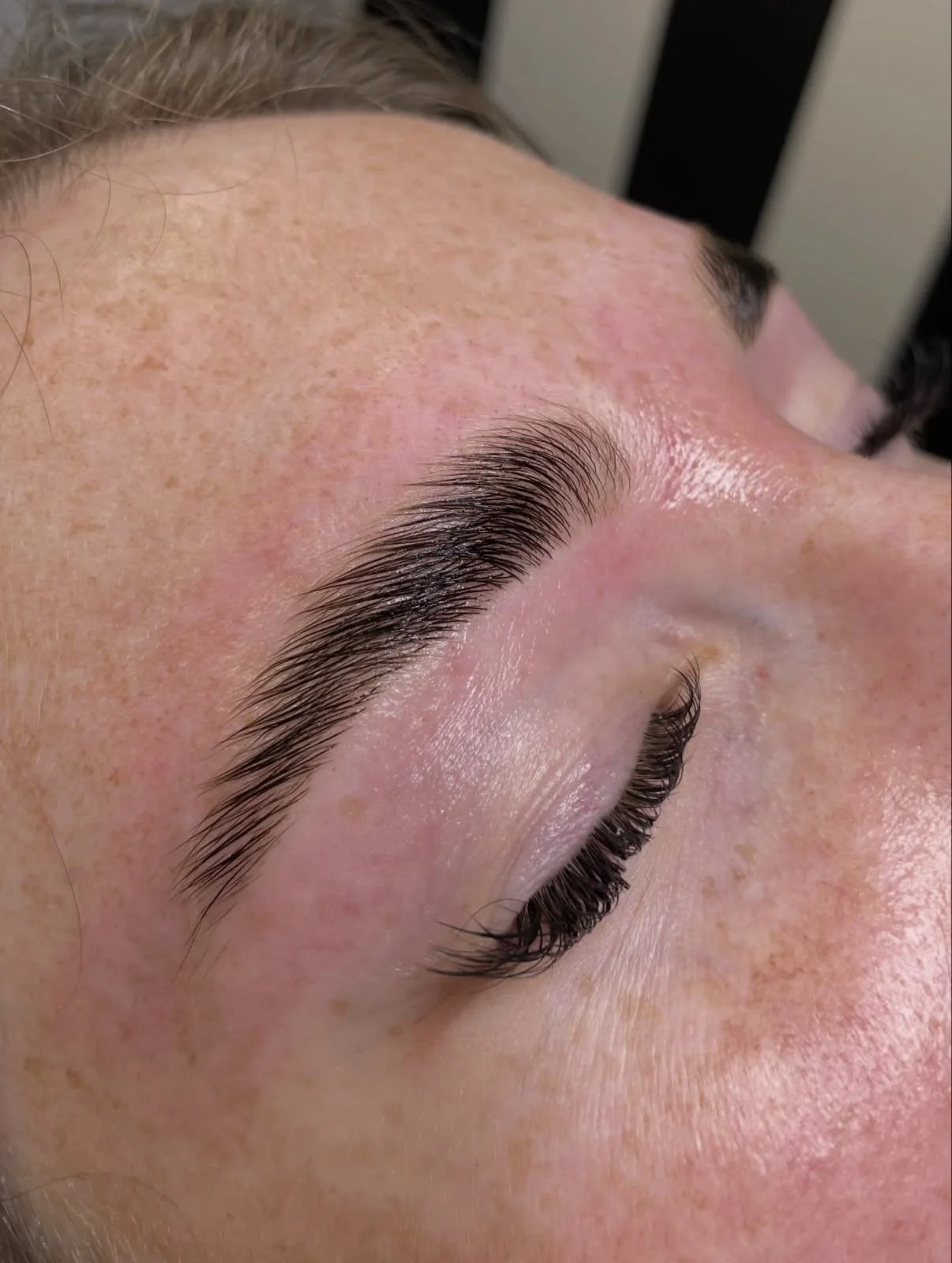 Close-up of a person's face with a focus on the eye area, showing freshly applied eyelash extensions or enhancements.