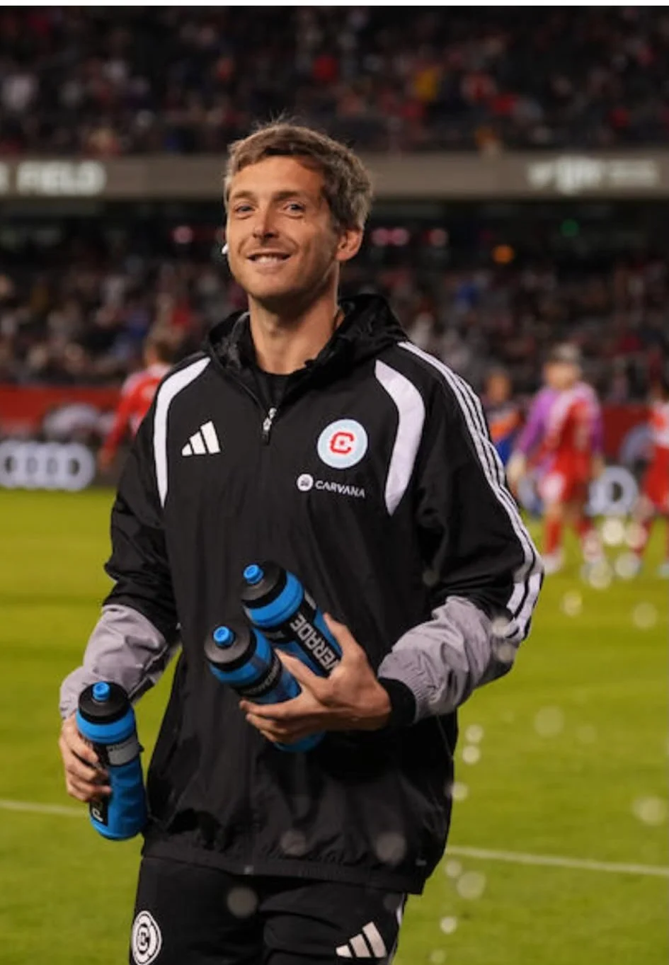 Andy Costin pitchside with water bottles, high performance sport specialist