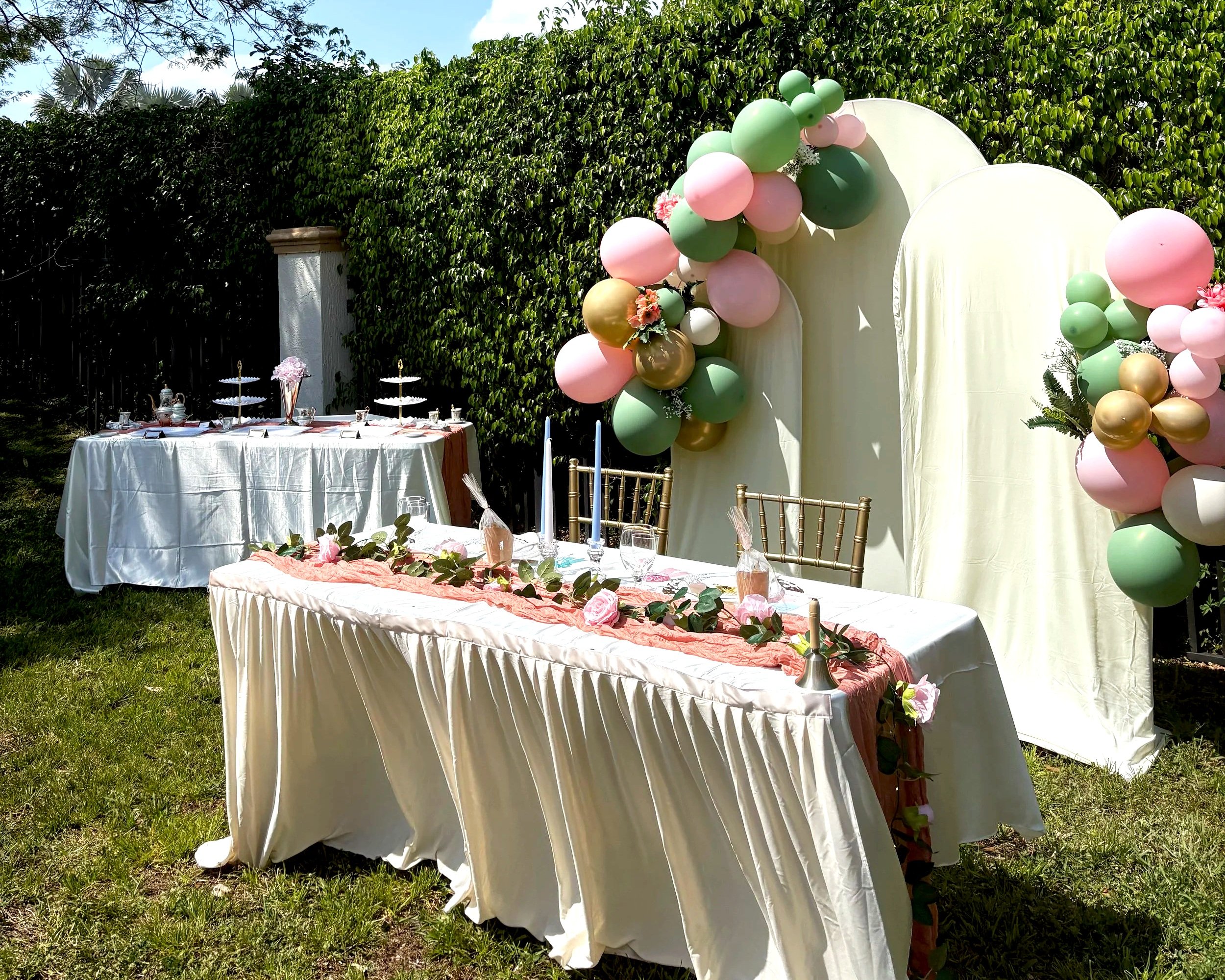 Decorated outdoor table setup with balloons and floral arrangements for celebration