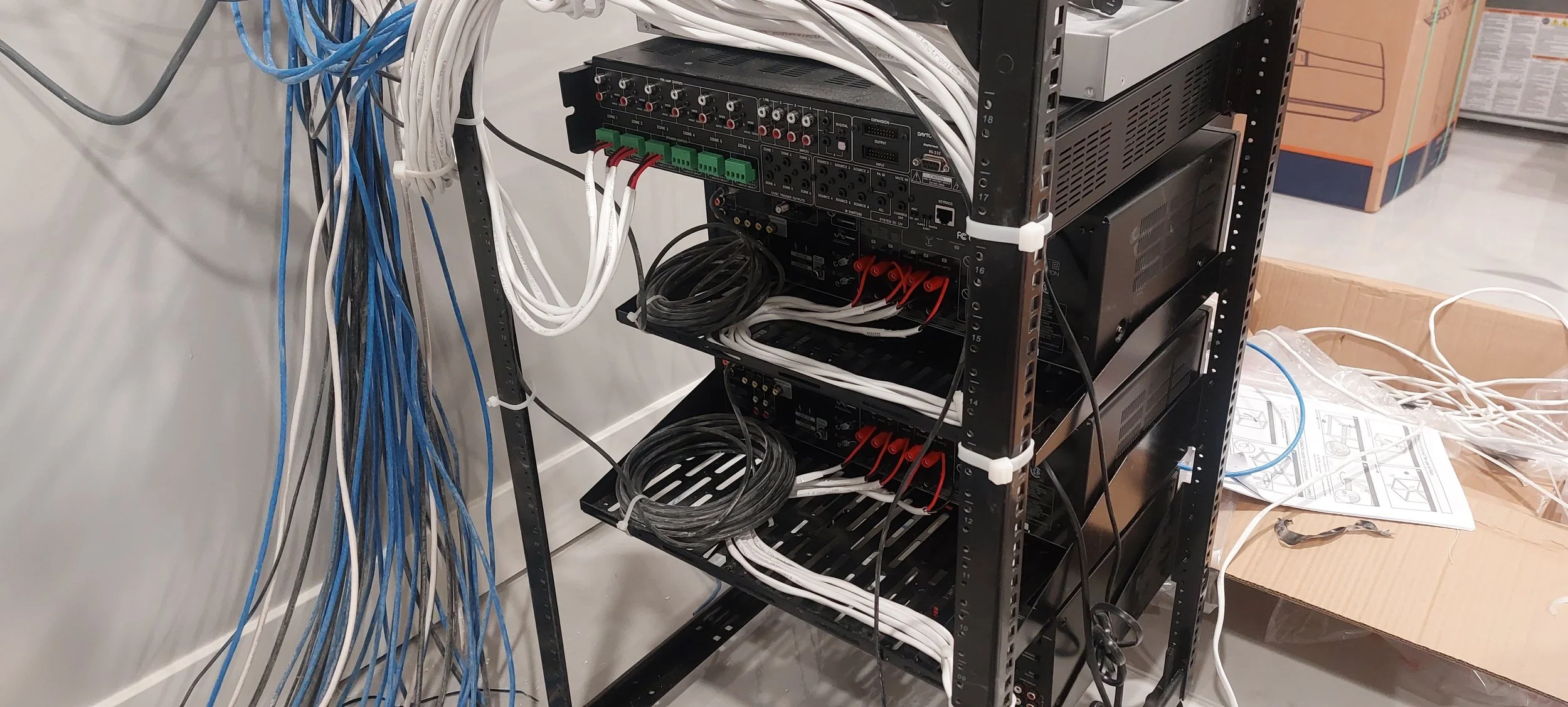 Networking equipment rack with organized cables, switches, and servers, and power distribution units mounted on the rack.