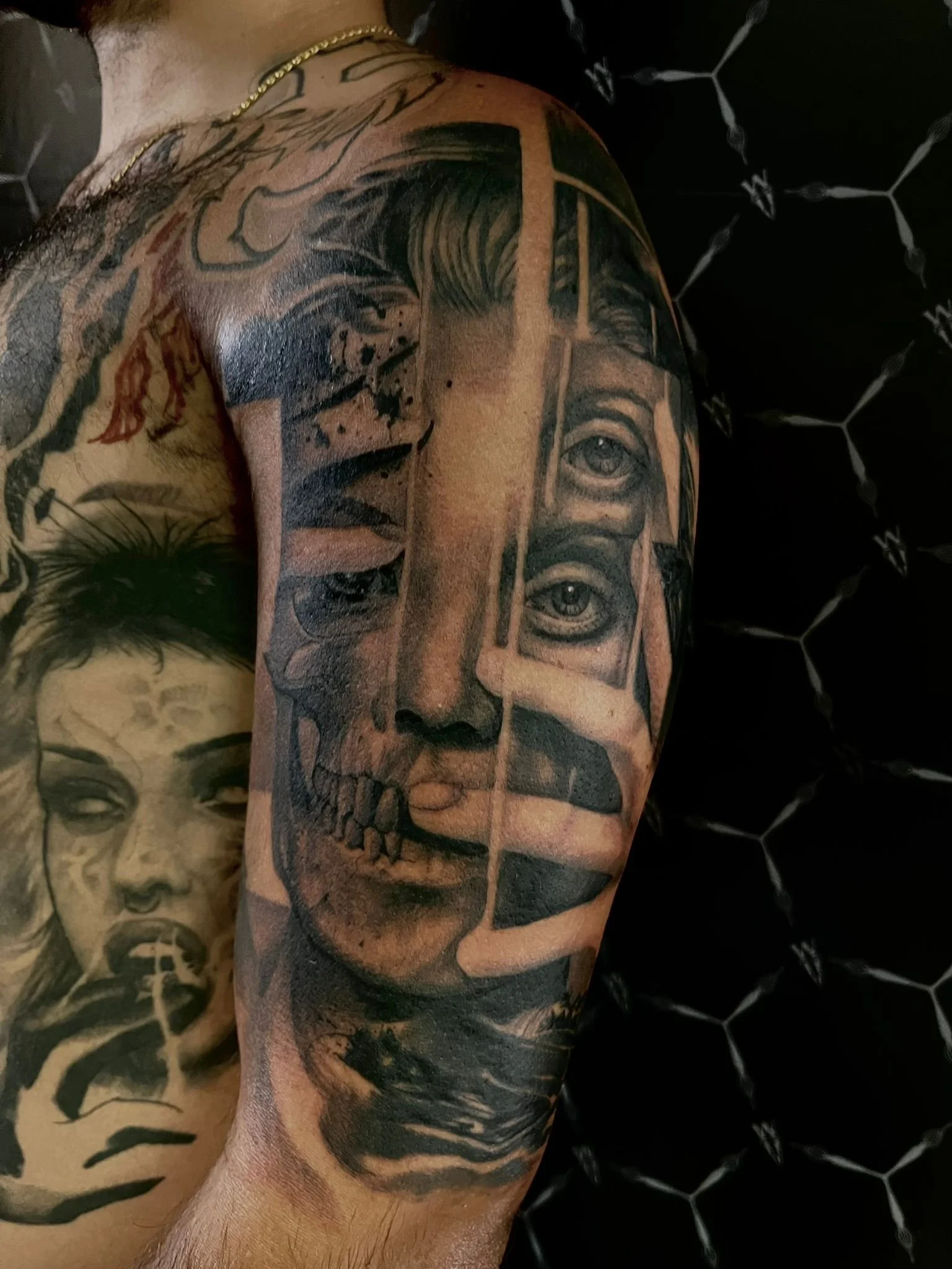 Tattoo of a human face with a split between a realistic side and a skull side, including eyes, nose, mouth, and hand near the face.
