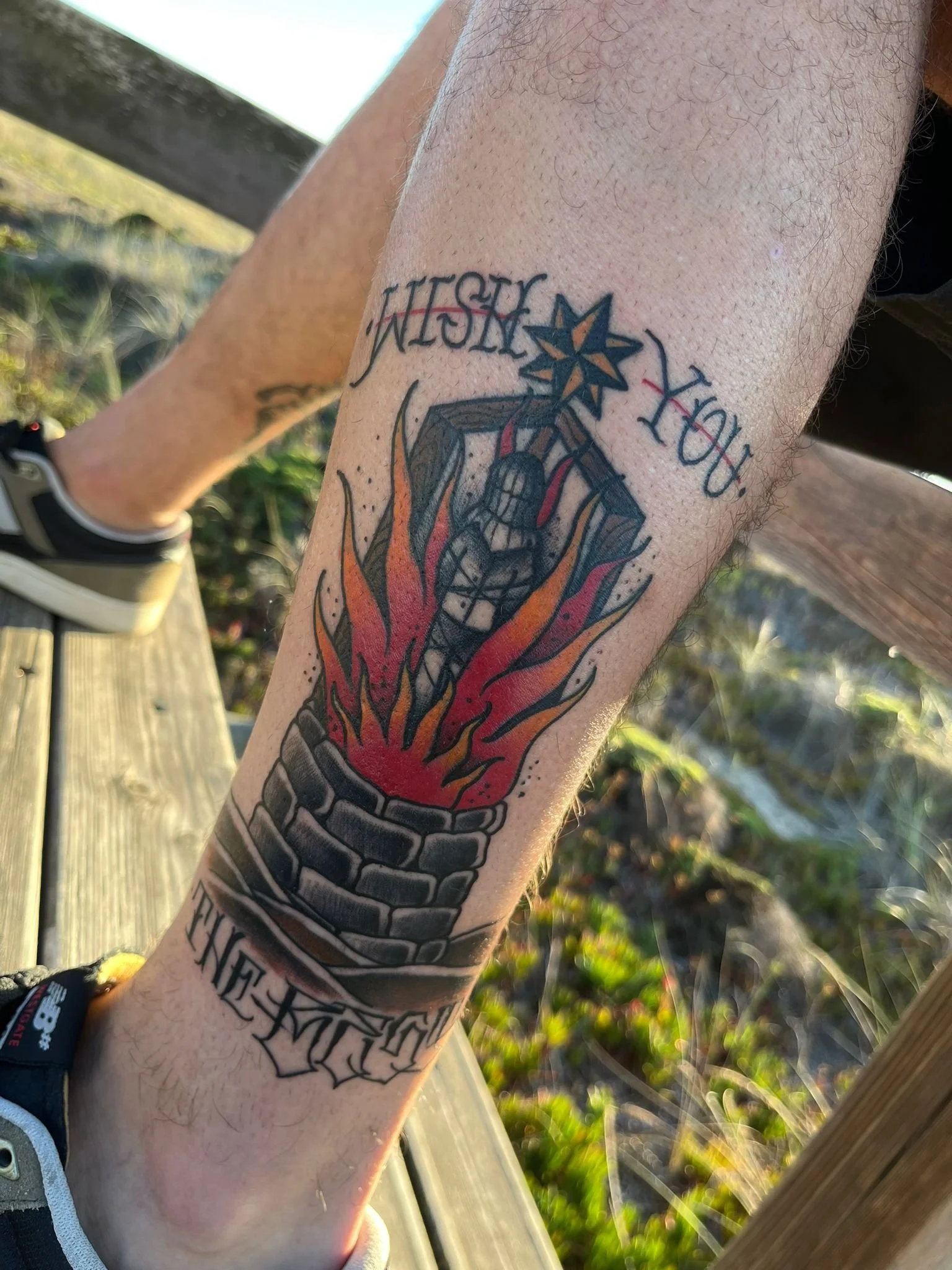 Tattoo of Jesus Christ on a cross, surrounded by flames and a pillar, with the words 'You Want' above and 'The King' below.