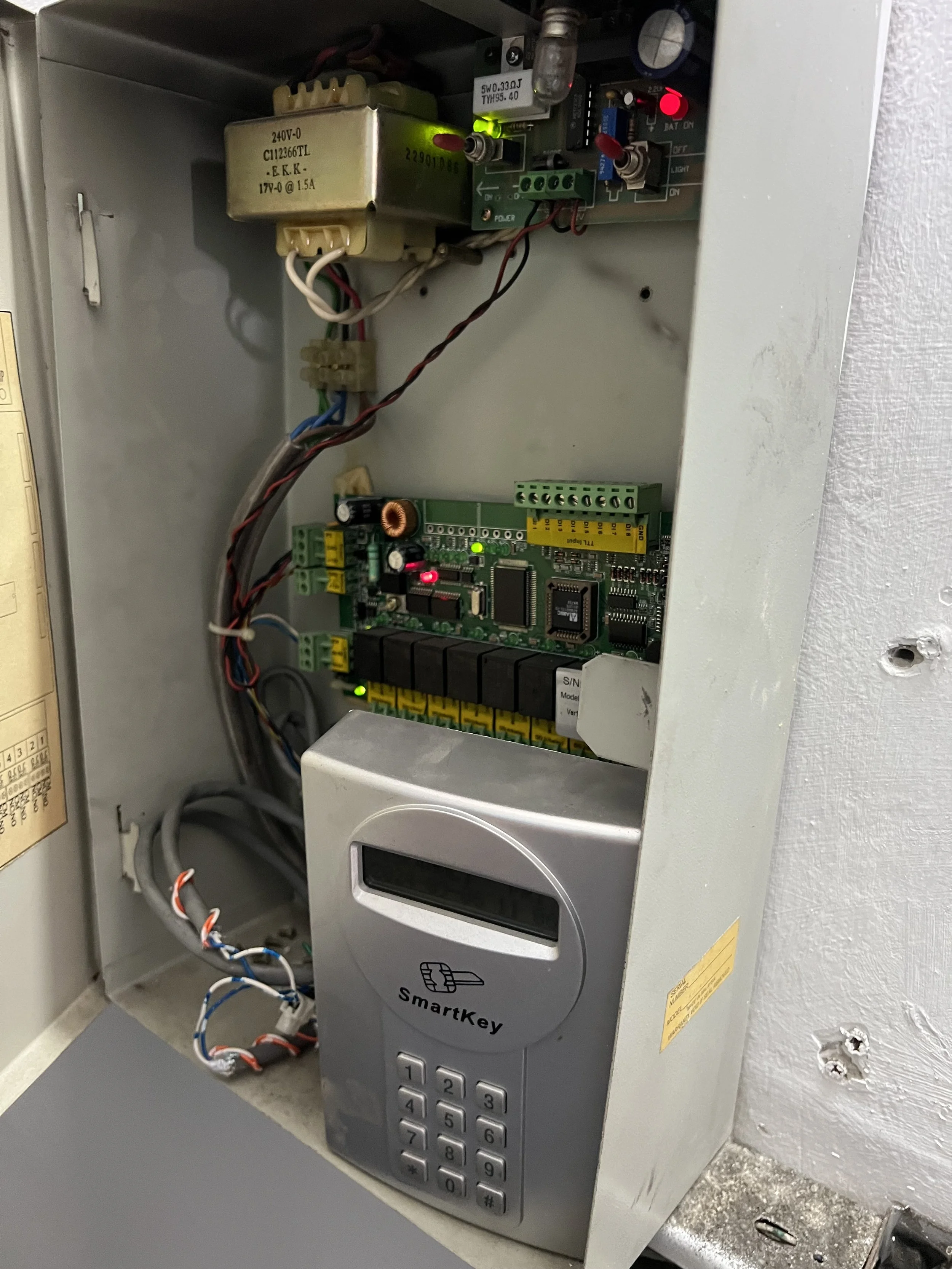 Inside an industrial access control panel with a SmartKey keypad lock, electronic circuit boards, wiring, and electrical components.