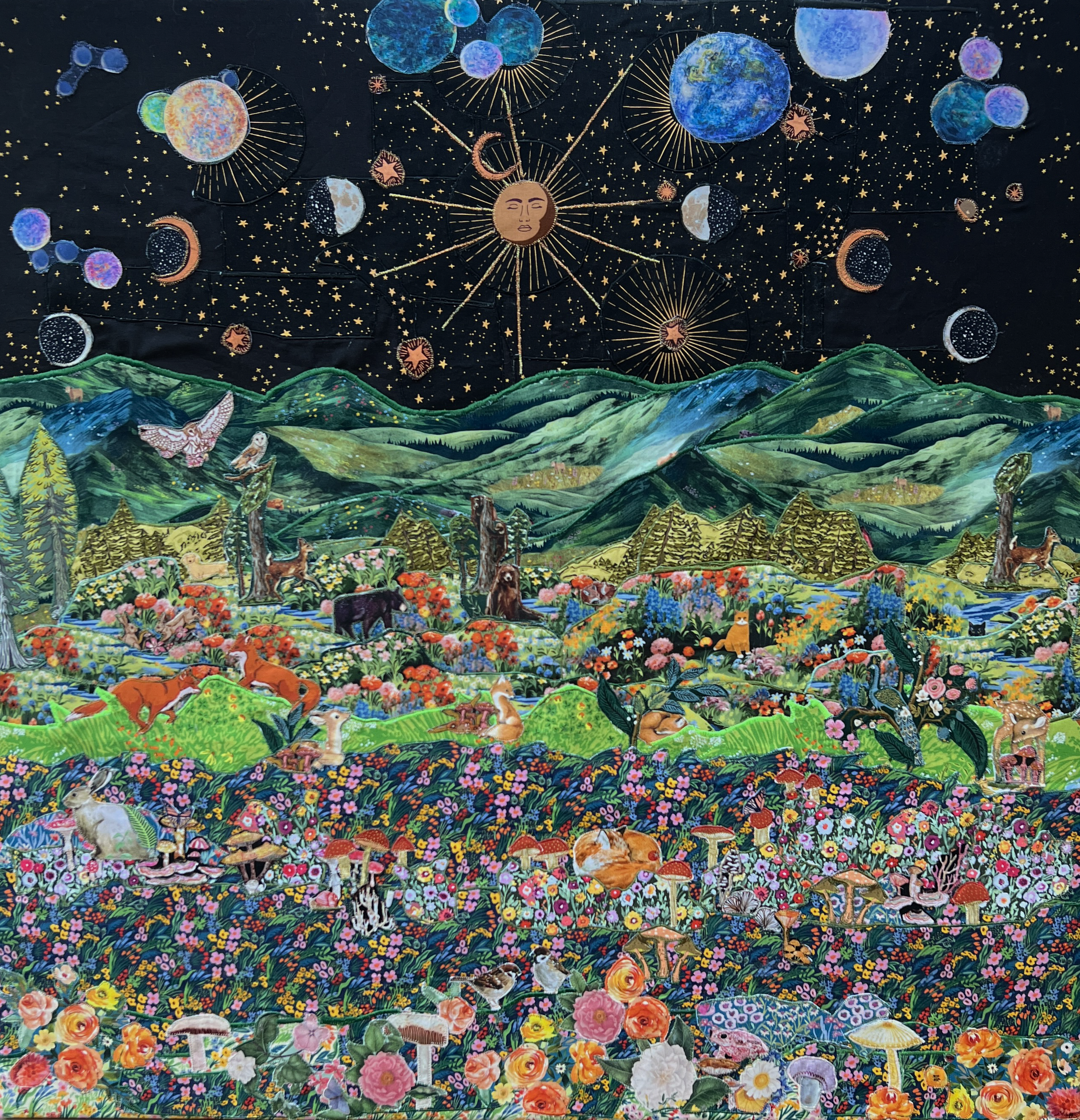 A colorful, intricate fabric collage depicting a vibrant nature scene with mountains, lush vegetation, animals, and a starry night sky with celestial bodies.