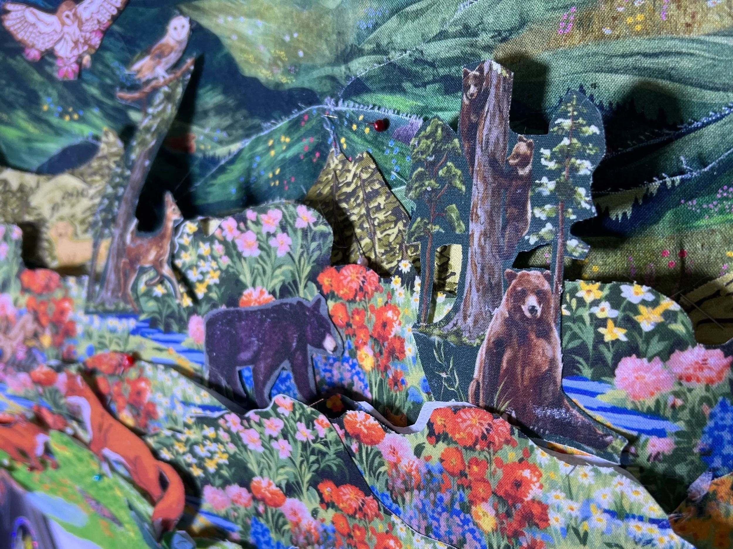 Three-dimensional multi-layered collage of a forest scene with bears, a wolf, a deer, butterflies, and colorful flowers, creating a vibrant nature landscape.
