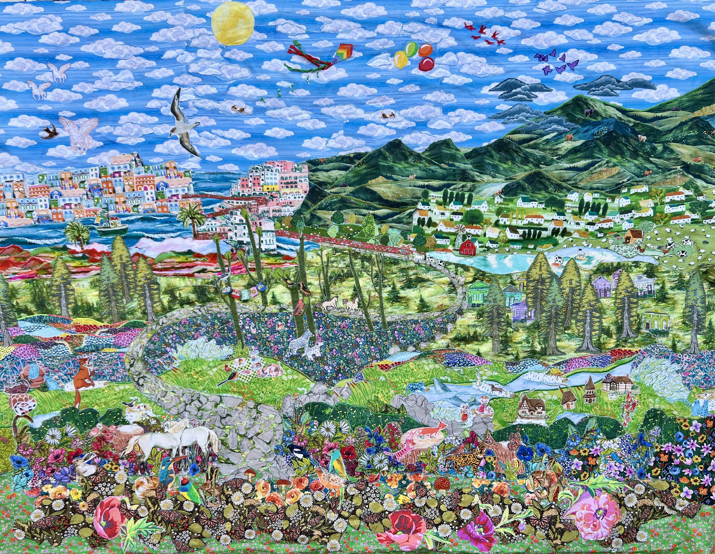 Large Wall Art Fabric Collage featuring vibrant, colorful landscape mural featuring a lively countryside scene with mountains, a town, animals, and nature elements under a bright sun and partly cloudy sky.