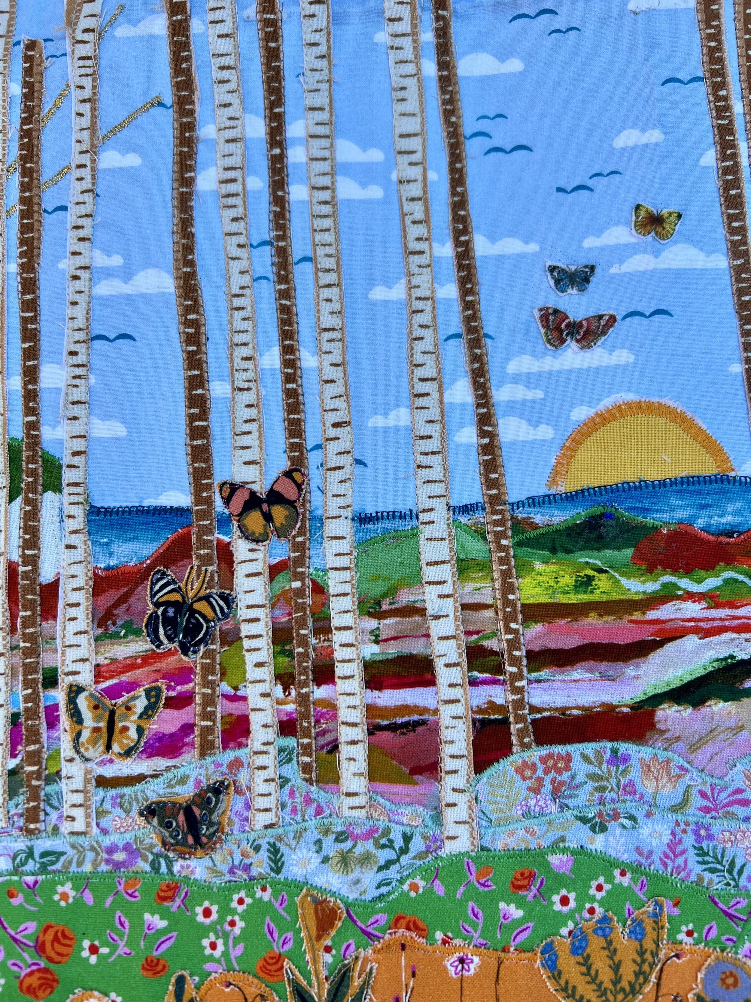 Detailed image of a fabric collage depicting a landscape with tall trees, butterflies, a sunrise over mountains and grass fields, on a blue sky background.
