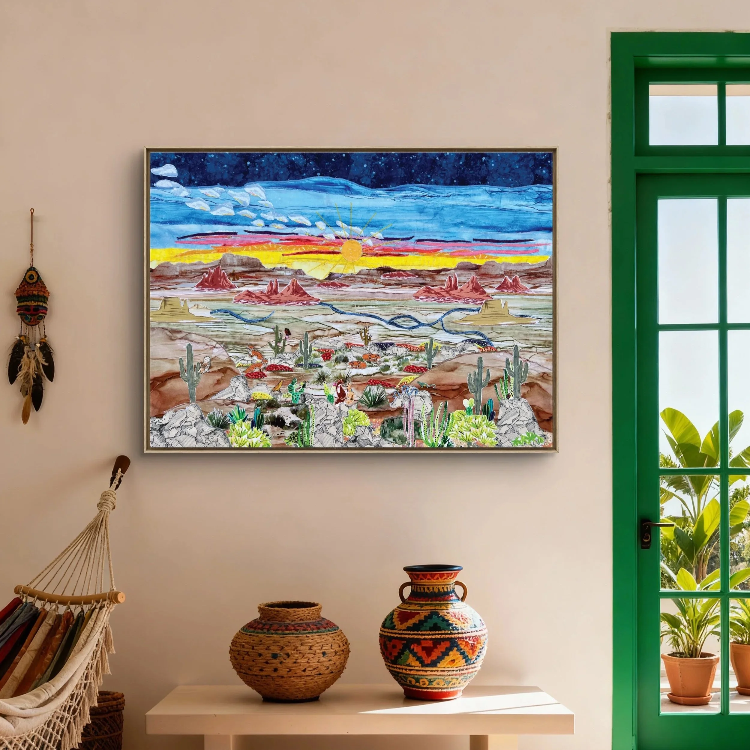Colorful Large Wall Art desert landscape fabric collage hanging on a beige wall, with pots and a hanging dreamcatcher nearby, and a green door with potted plants outside.