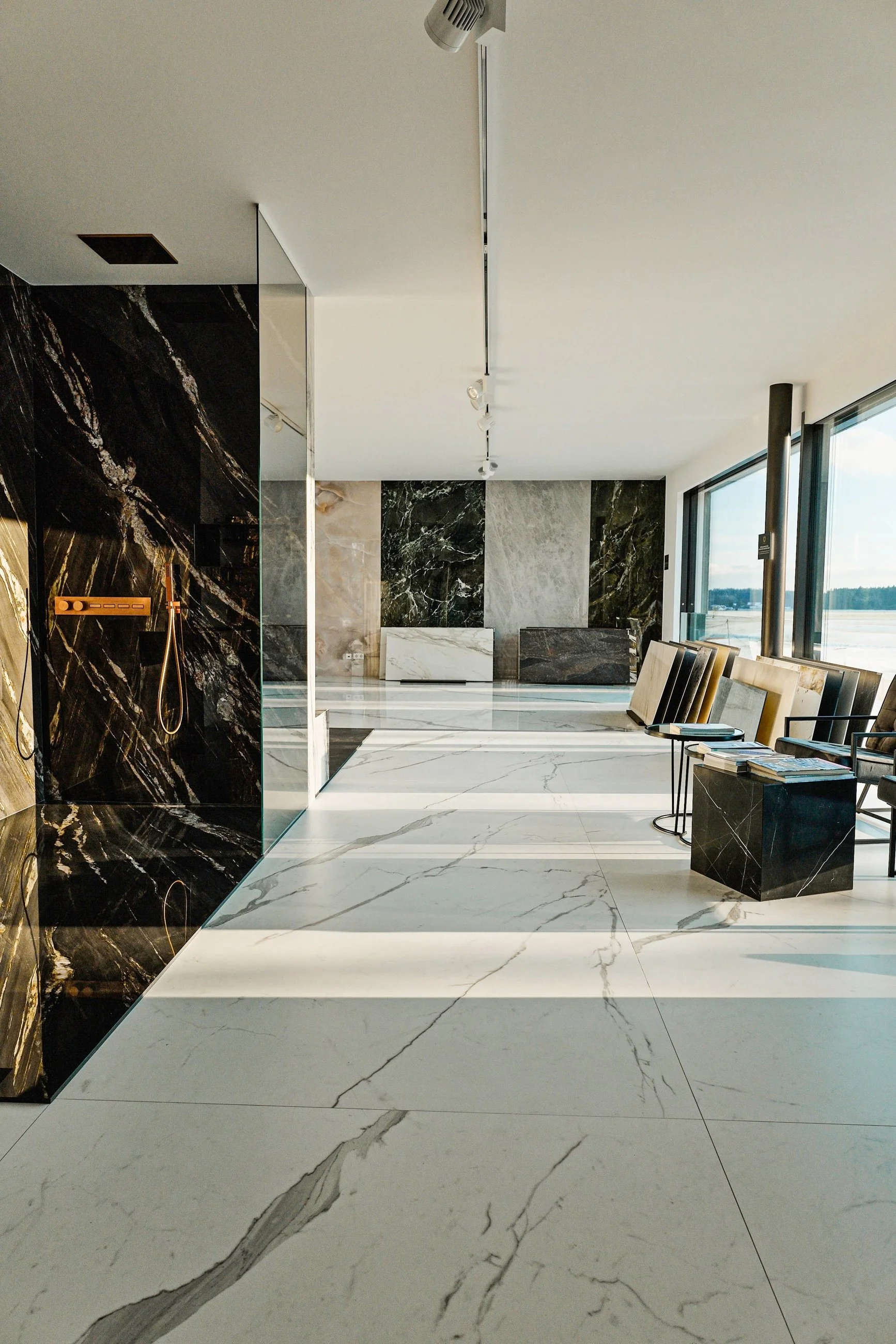 Moderne Lobby mit weißen und schwarzen Marmorfliesen, großen Fenstern und bequemen Sitzgelegenheiten.