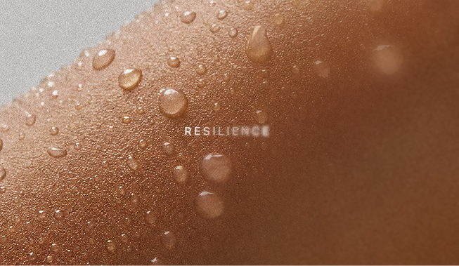 Close-up of a skin surface with water droplets and the word 'RESILIENCE' printed on it.