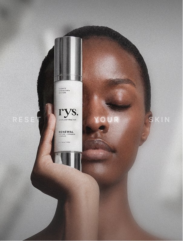 A woman with short hair holding a skincare bottle in front of her face, covering one eye, with the words 'RESET YOUR SKIN' superimposed on the image.