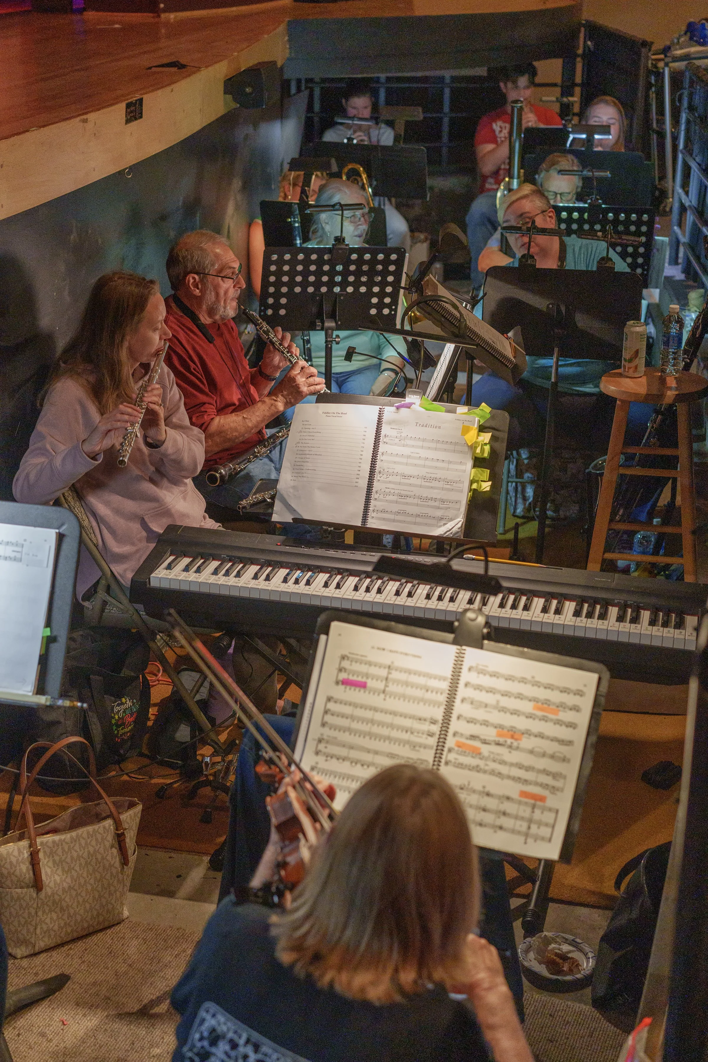 Orchestra rehearsal with musicians playing wind, string, and keyboard instruments at Ashe County Little Theatre in Ashe county North Carolina