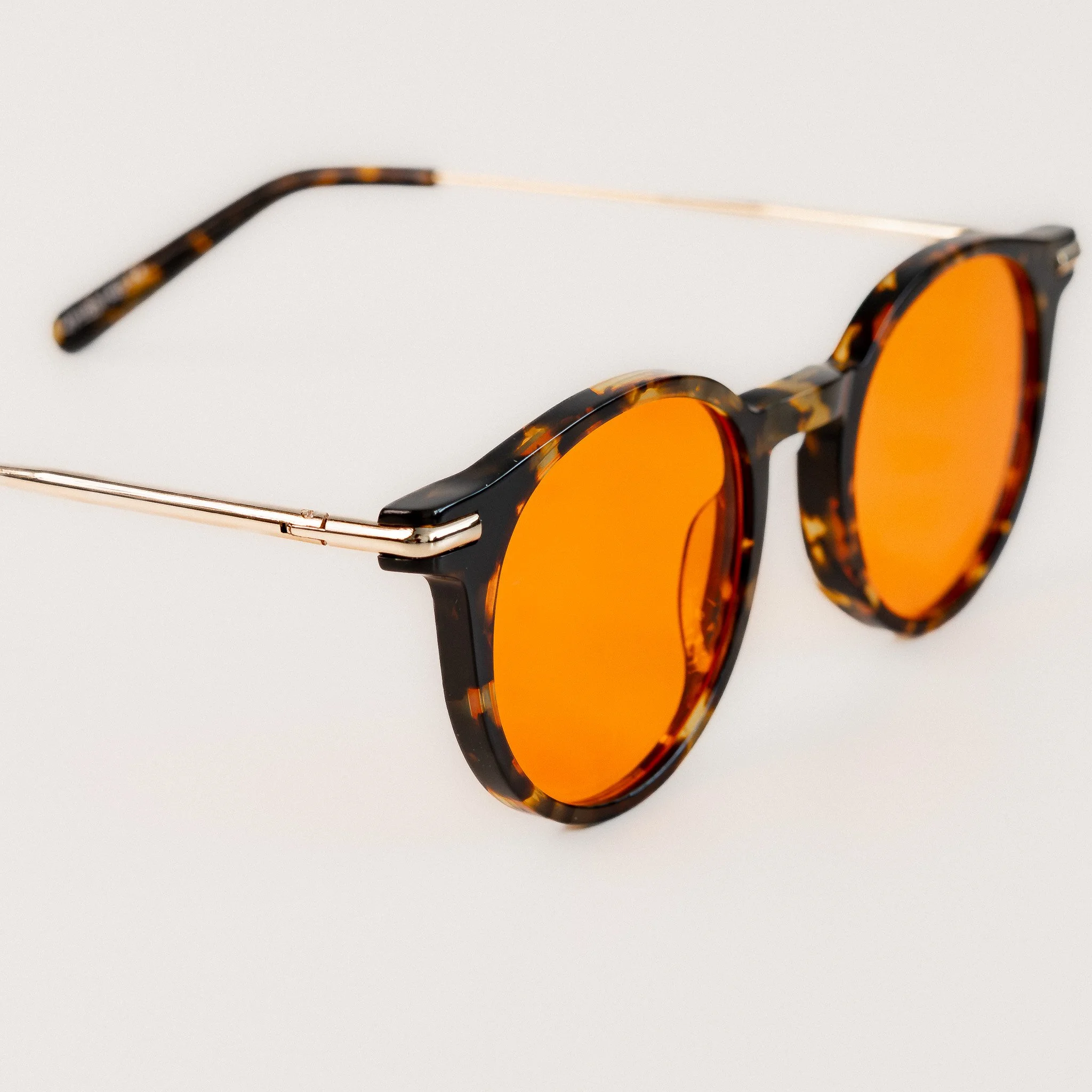 Alden blue light glasses up close front view tortoise acetate round frame with amber orange lenses