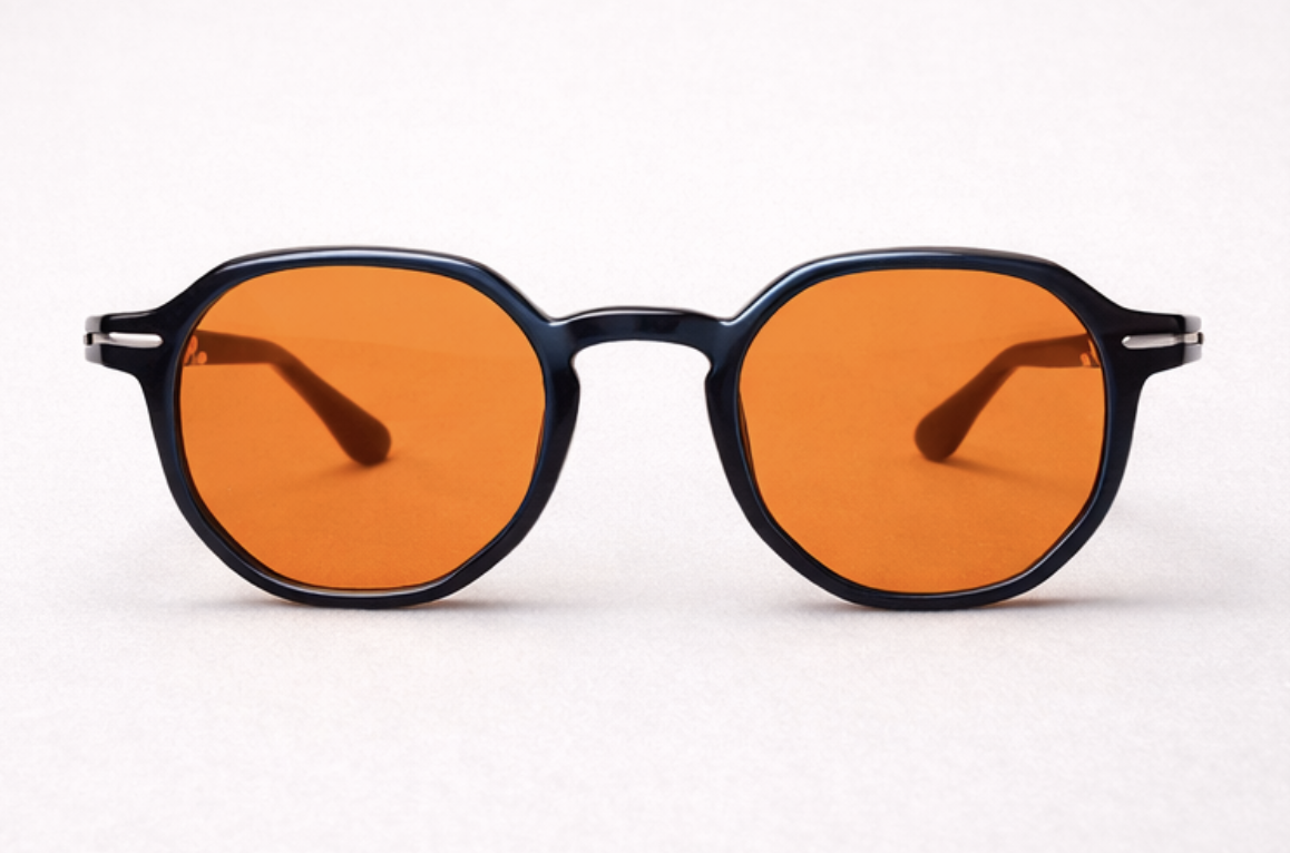 Pair of black sunglasses with orange-tinted lenses on a white background.