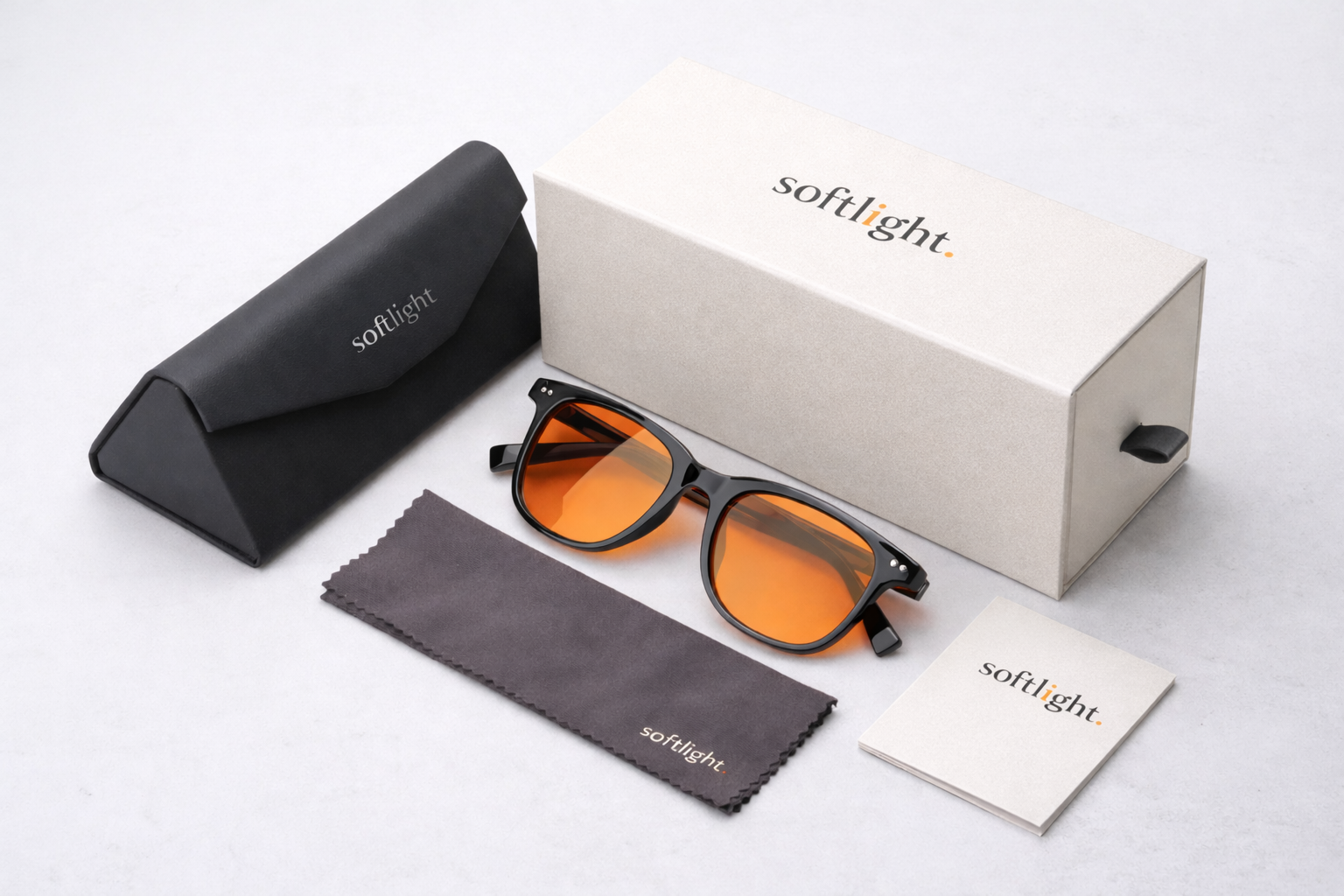 Pair of black sunglasses with orange-tinted lenses, softlight branded cleaning cloth, black carrying case, user manual, and a beige packaging box on a white surface.