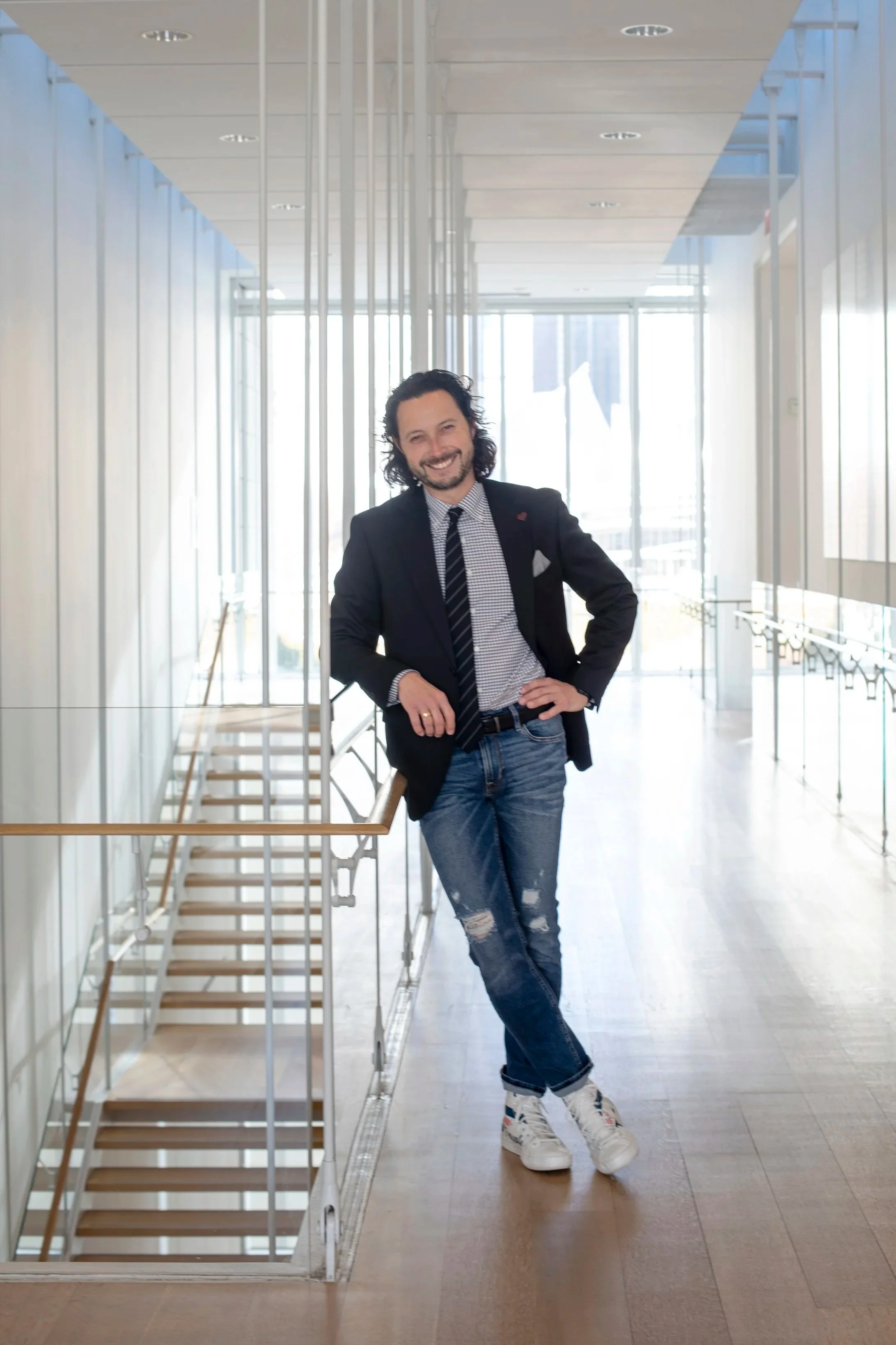Dr. Tommy Z, wearing a blazers and jeans, standing in The Art Museum in Chicago
