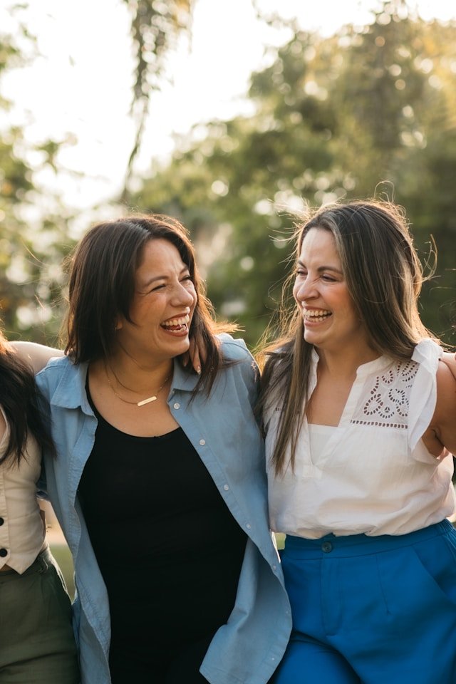 3 adult sisters laughing together after family therapy