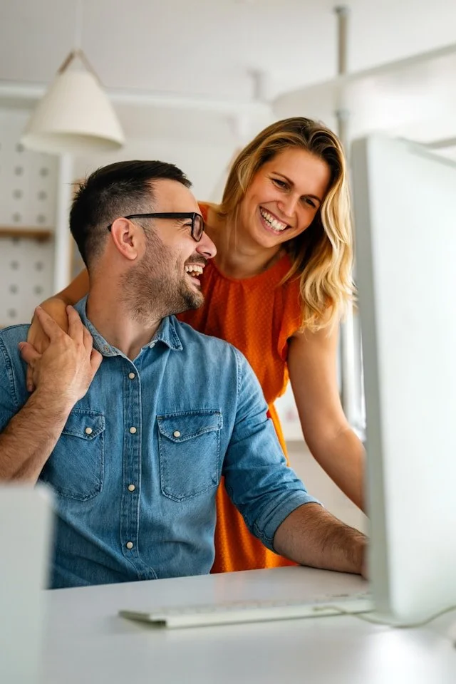 couple laughing during virtual couples counseling from home