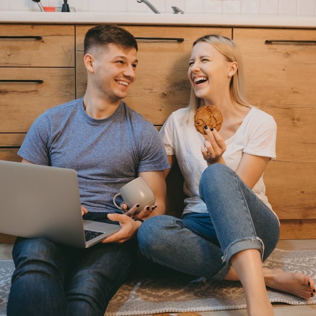 engaged couple laughing during online premarital counseling  in Boston