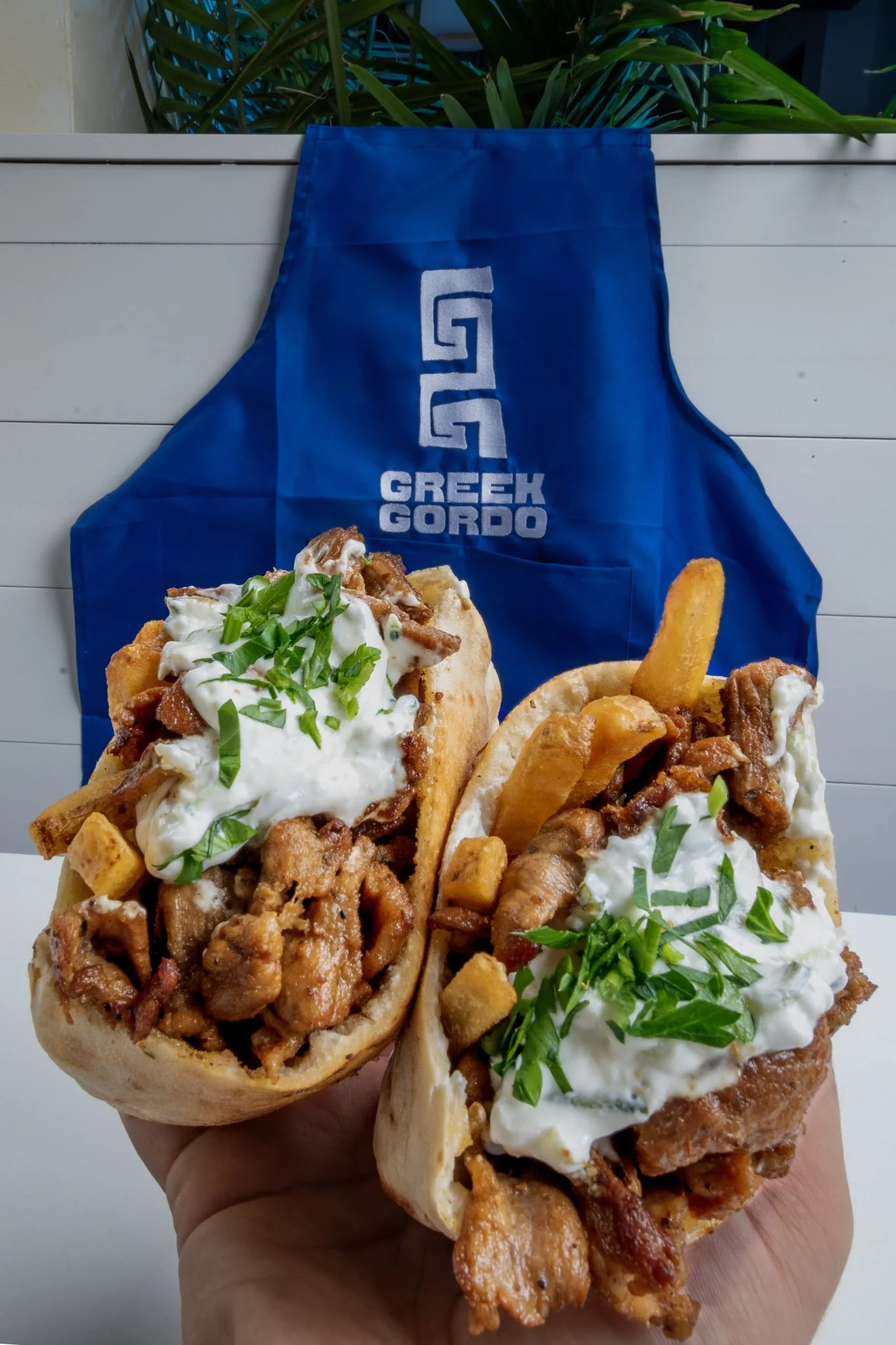 Best Greek gyros sandwiches filled with seasoned meat, topped with tzatziki sauce and chopped green herbs "Greek Gordo"