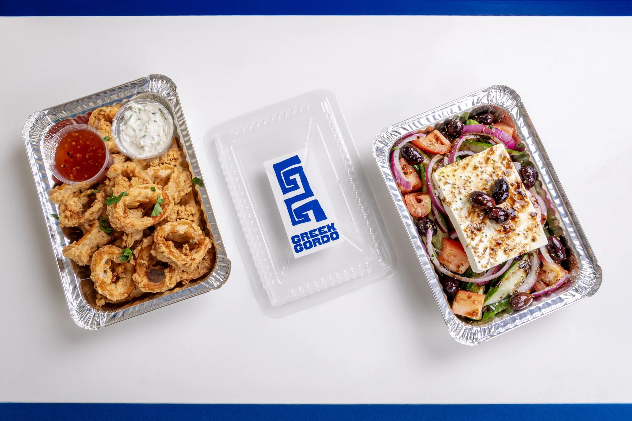 Best Greek food, one with fried calamari and dipping sauces, the other with a Greek salad topped with feta cheese from Greek Gordo