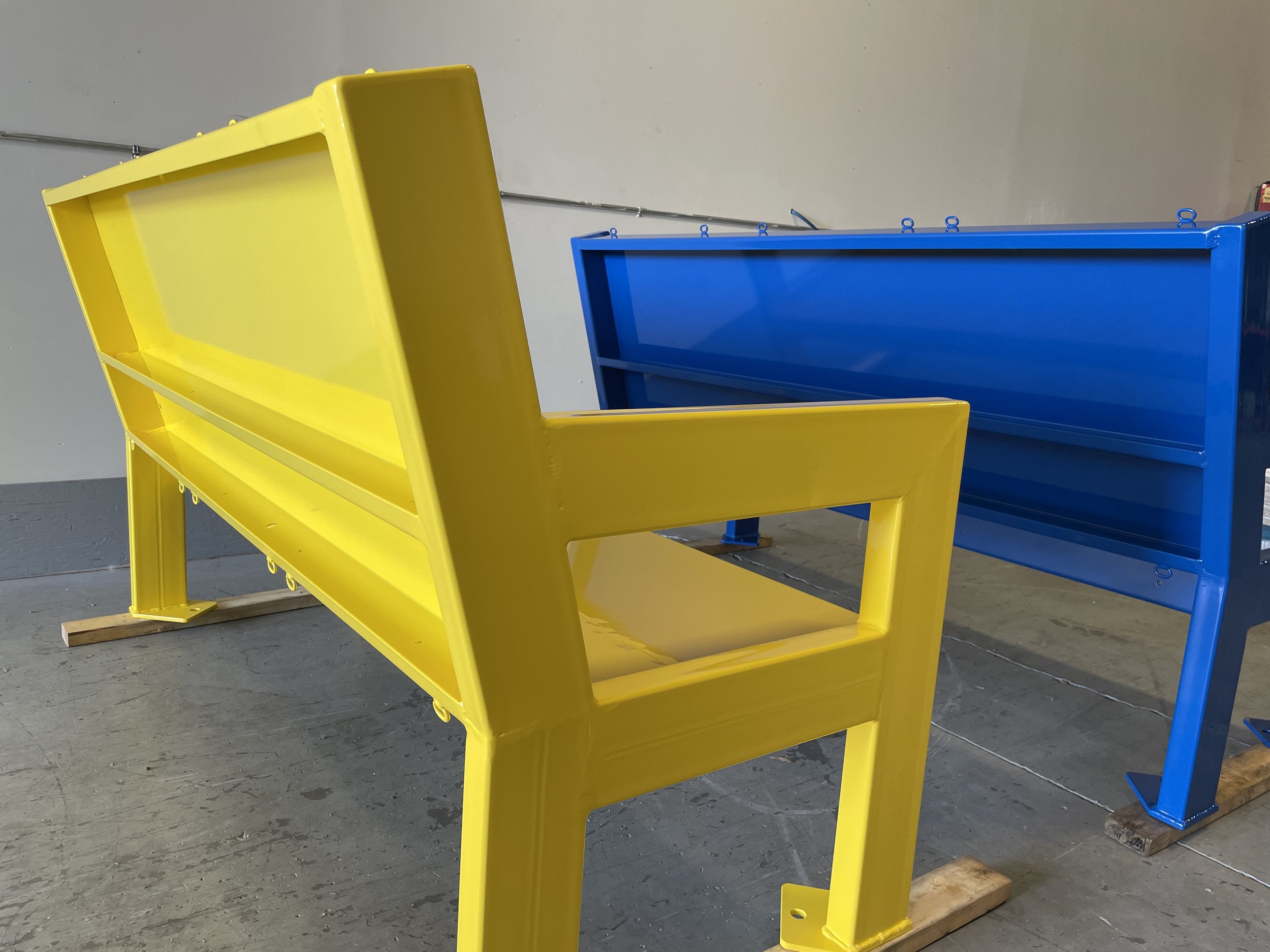 Yellow and blue metal benches in a warehouse or workshop.