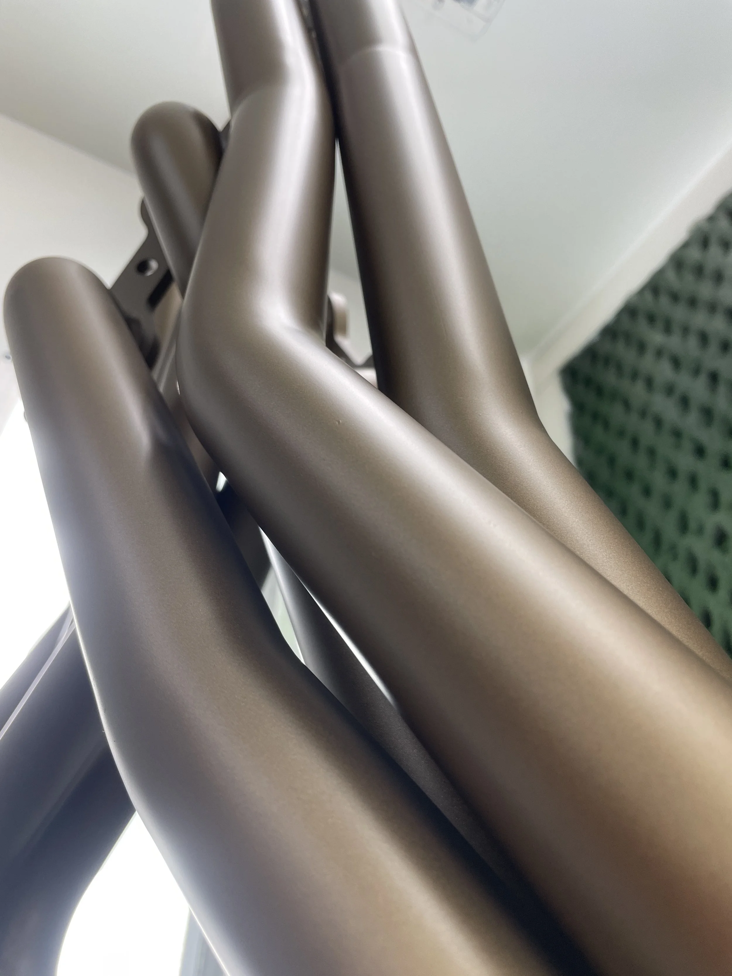 Close-up of a metallic exercise or dental chair in a room with white walls and green carpet.