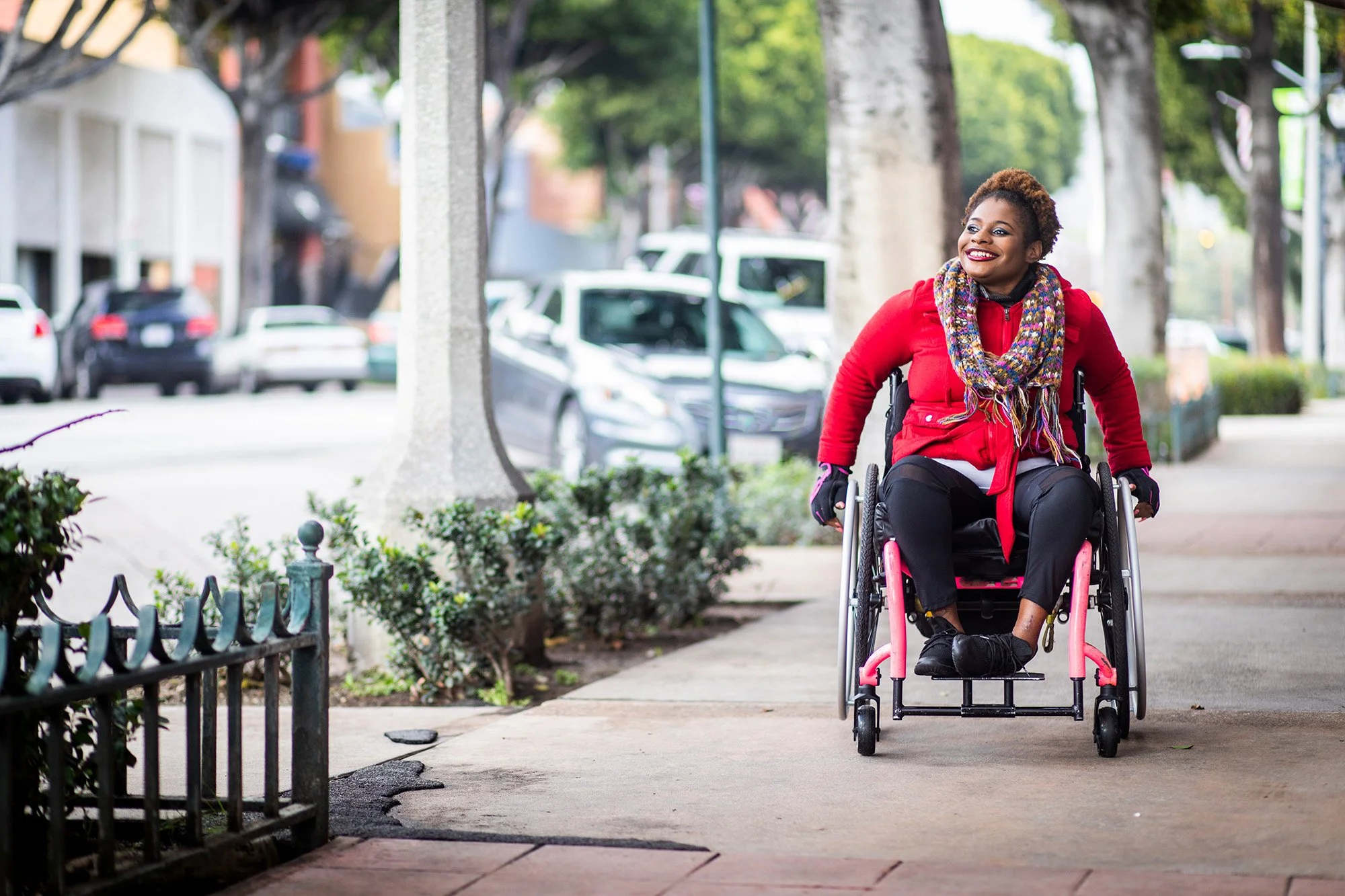 Image of woman using a wheelchair on a city street.