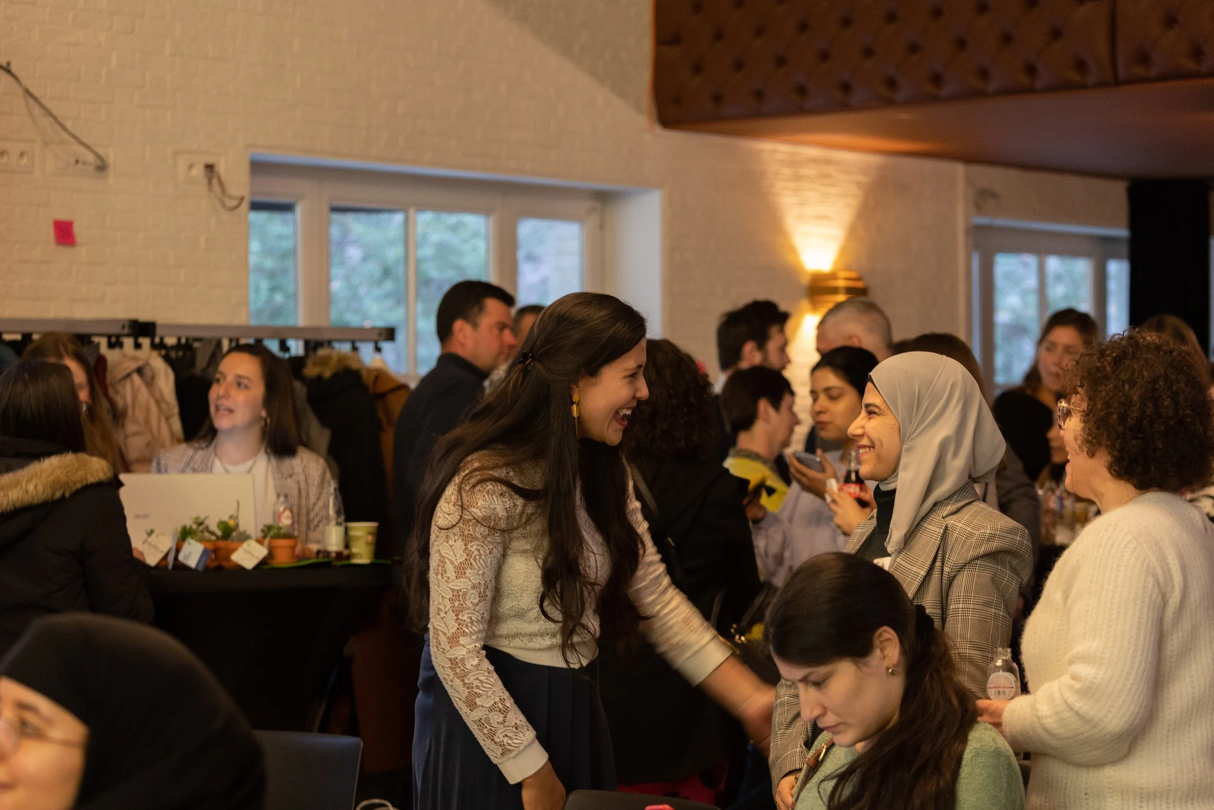 People socializing and smiling at an indoor gathering or event.