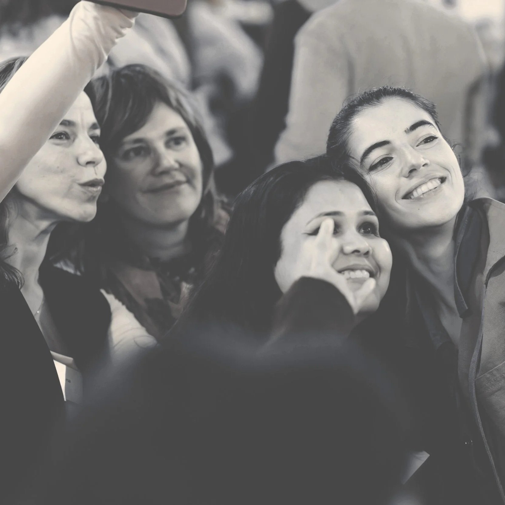 Group of women taking a selfie together at an event, smiling and posing for the camera.