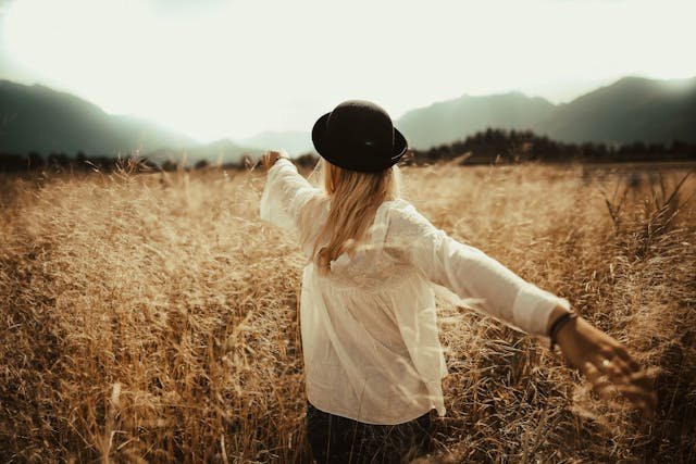 woman with arms stretched in a field