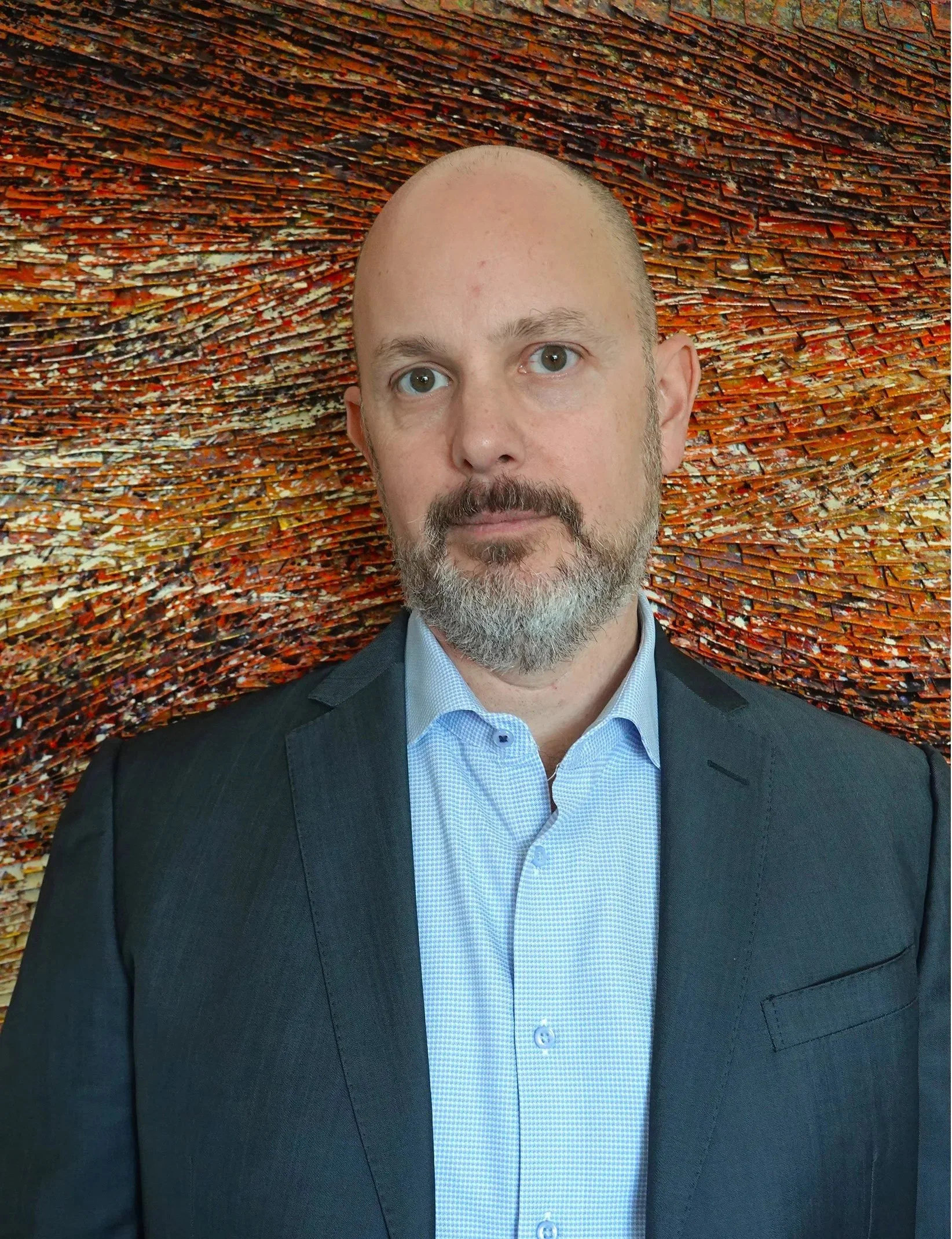 Lawyer Eric Pettit in a suit in front of an abstract textured background.