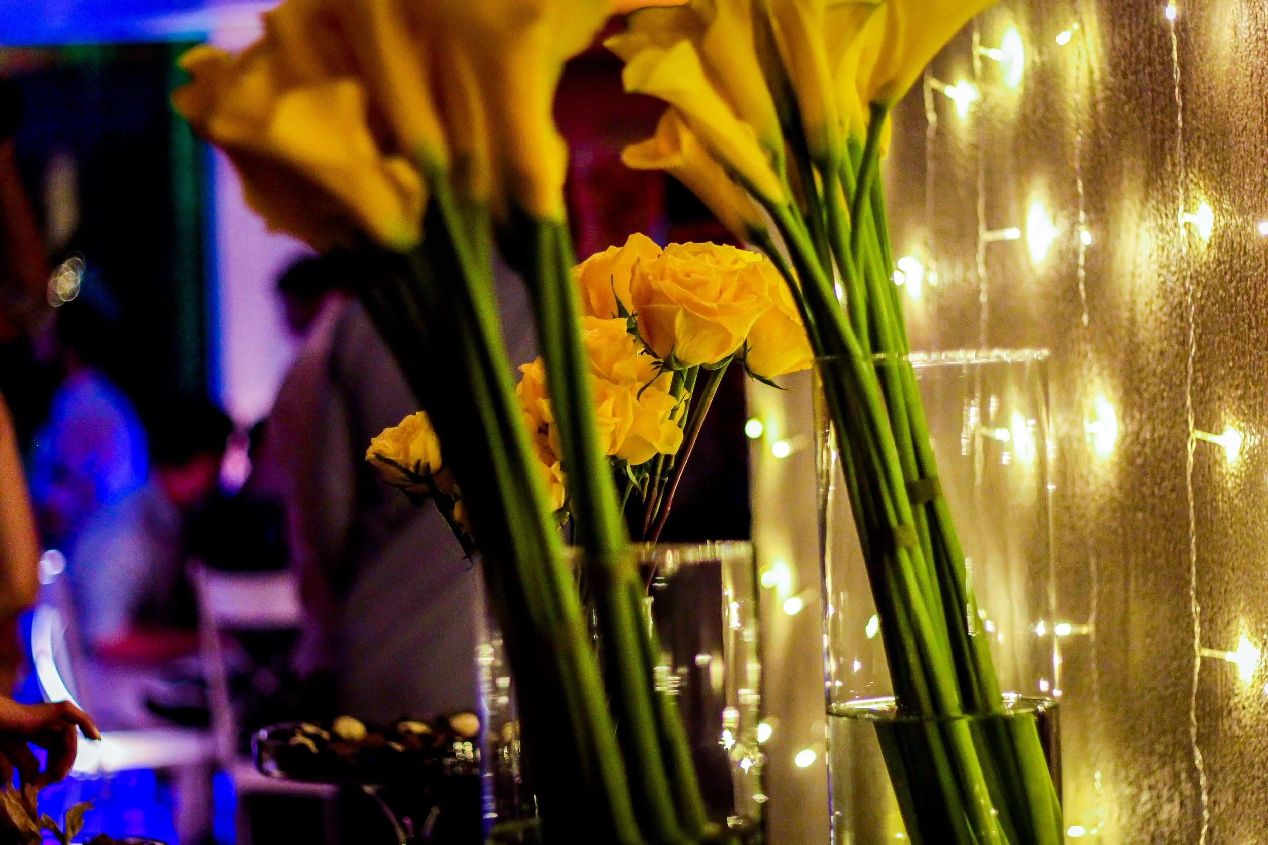 Arranjos de flores amarelas decorativos ao lado de luzes de Natal