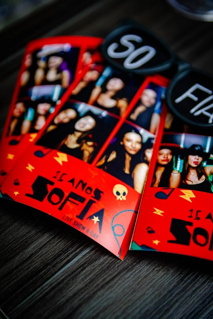 Convite para o show de banda chamado SOFIA com fotos de artistas, artwork colorido com elementos de estrelas e relâmpagos, e óculos de sol com os textos 'SO' e 'FI'