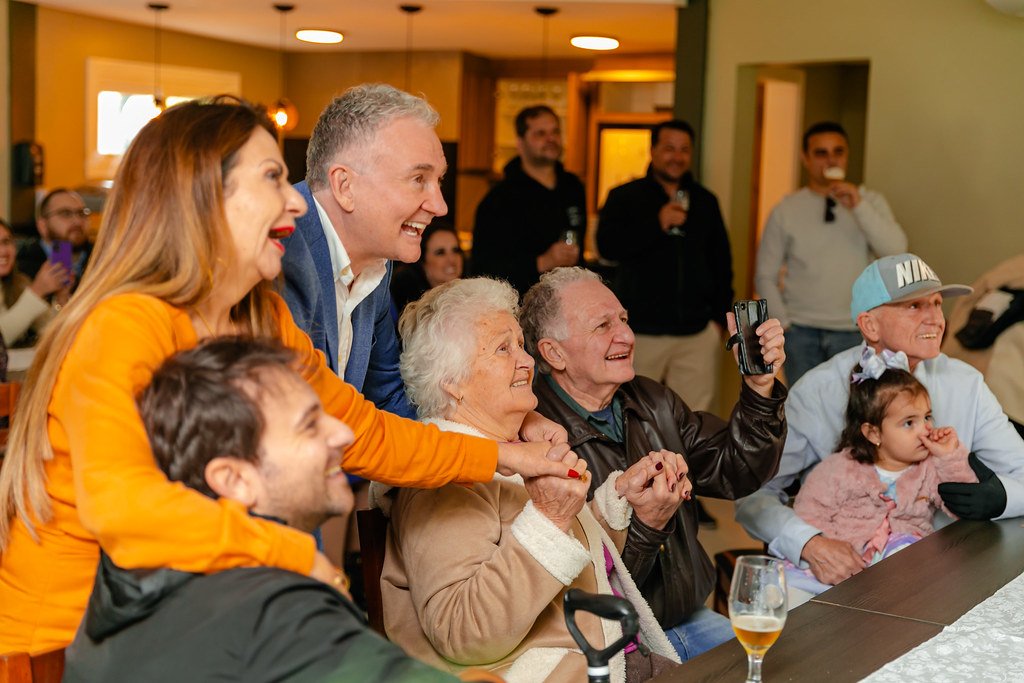 Grupo de pessoas sorrindo e se divertindo em um evento social em uma sala de jantar