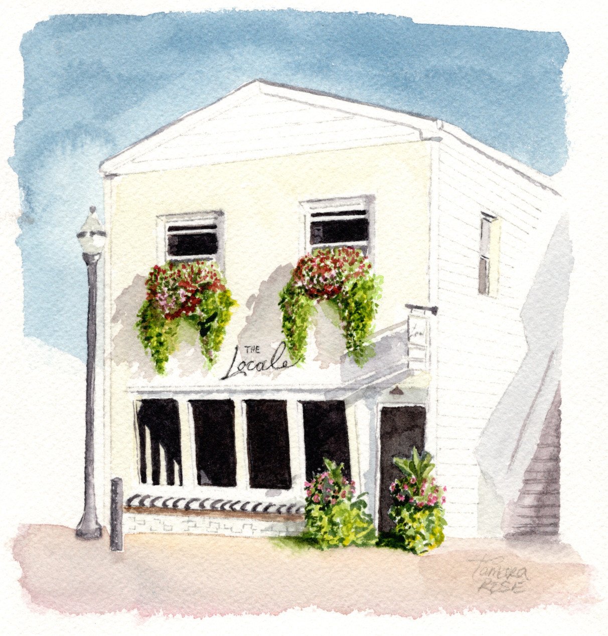 White brick building with window boxes overflowing with flowers and a black and white stripped bench in front of dark windows.