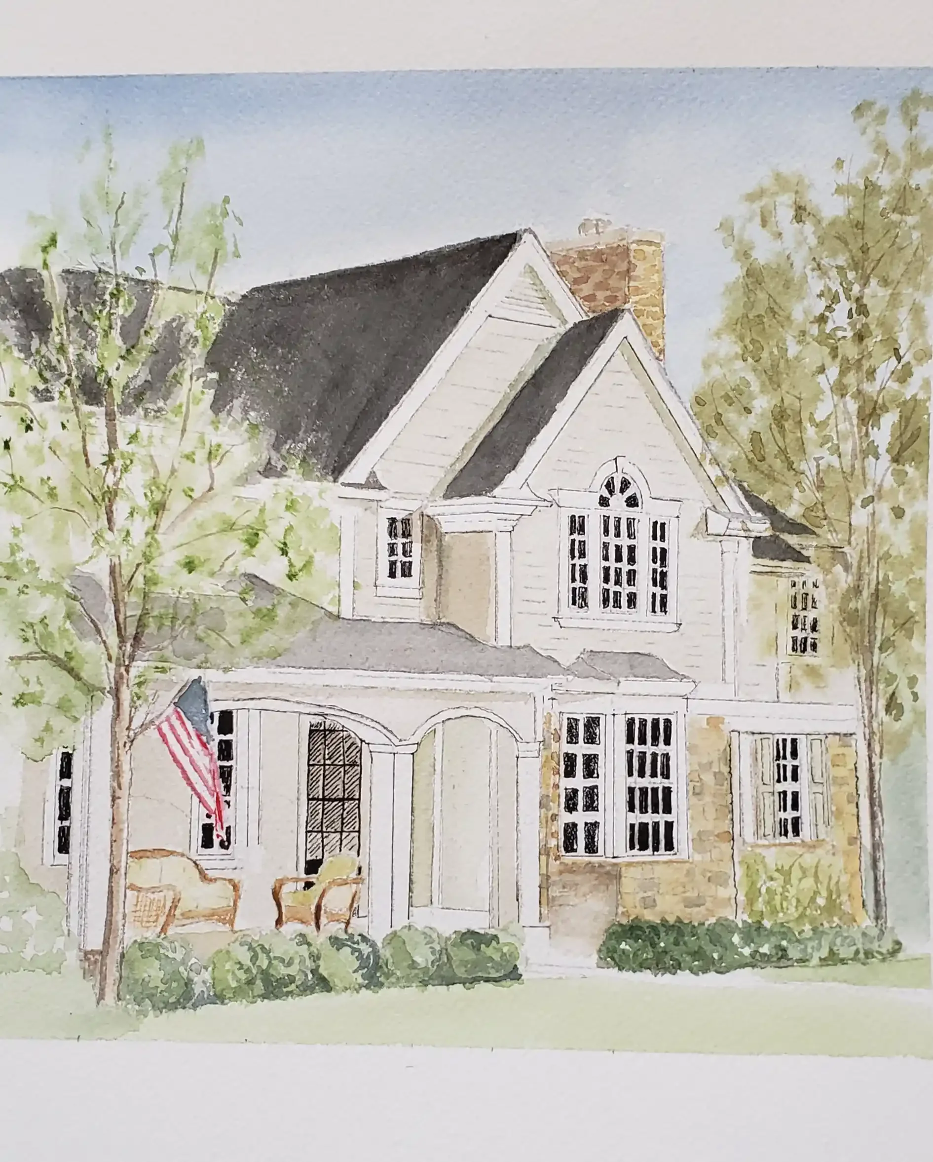 Watercolor painting of a two-story house with a dark roof, white siding, multiple windows, a front porch with an American flag, surrounded by trees and landscaping.
