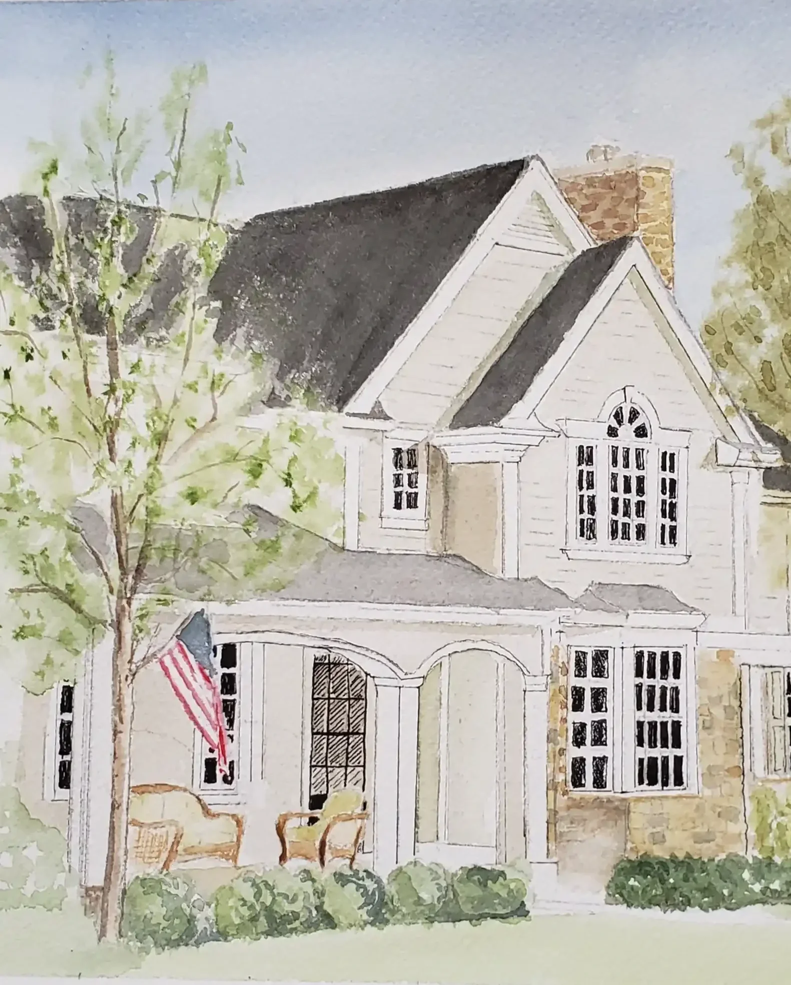 Watercolor painting of a white two-story house with a black roof, front porch with chairs, a tree, an American flag, and lush green bushes.