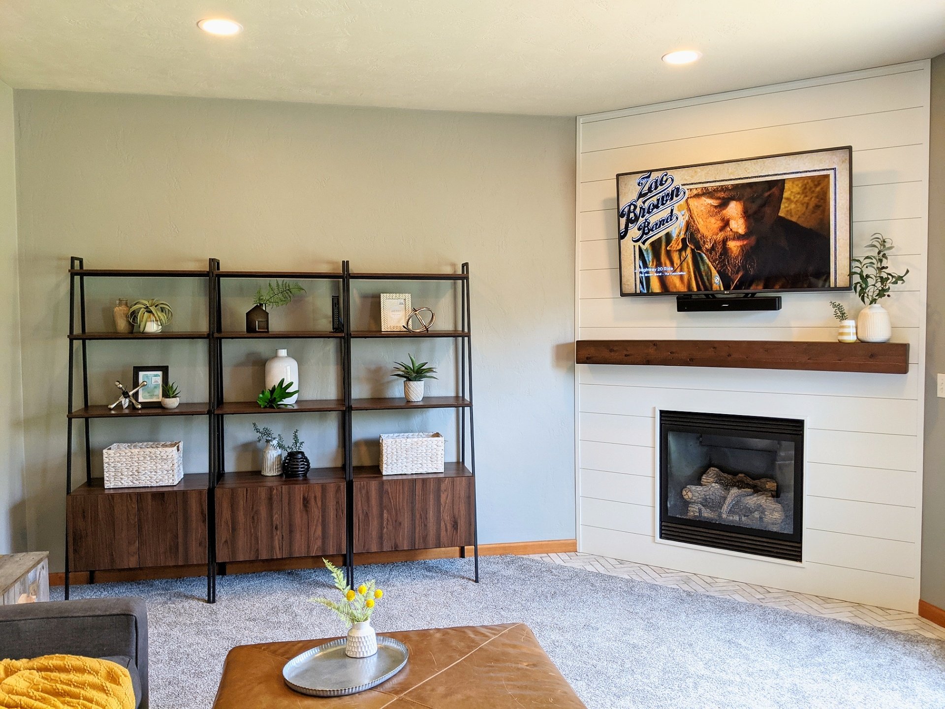 Photo of a light, bright, modern living room with a custom gas fireplace wrap by Revival Homes.
