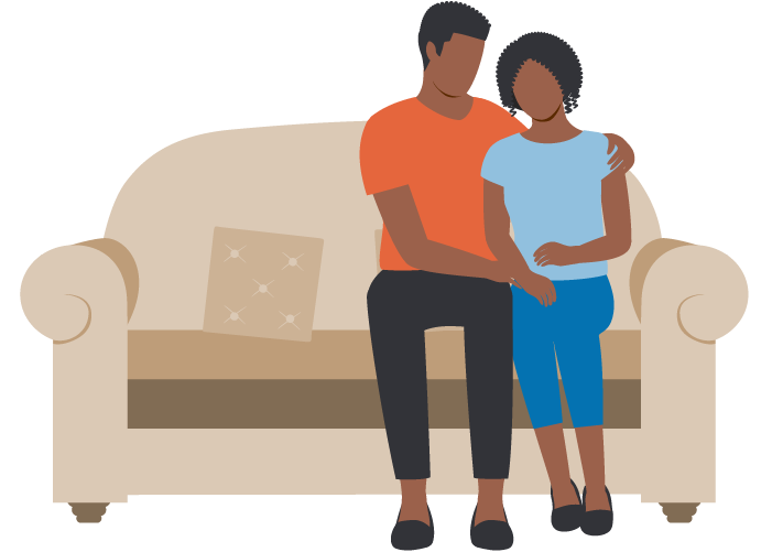 A man and a girl sitting close together on a beige couch, with the man's arm around the girl.