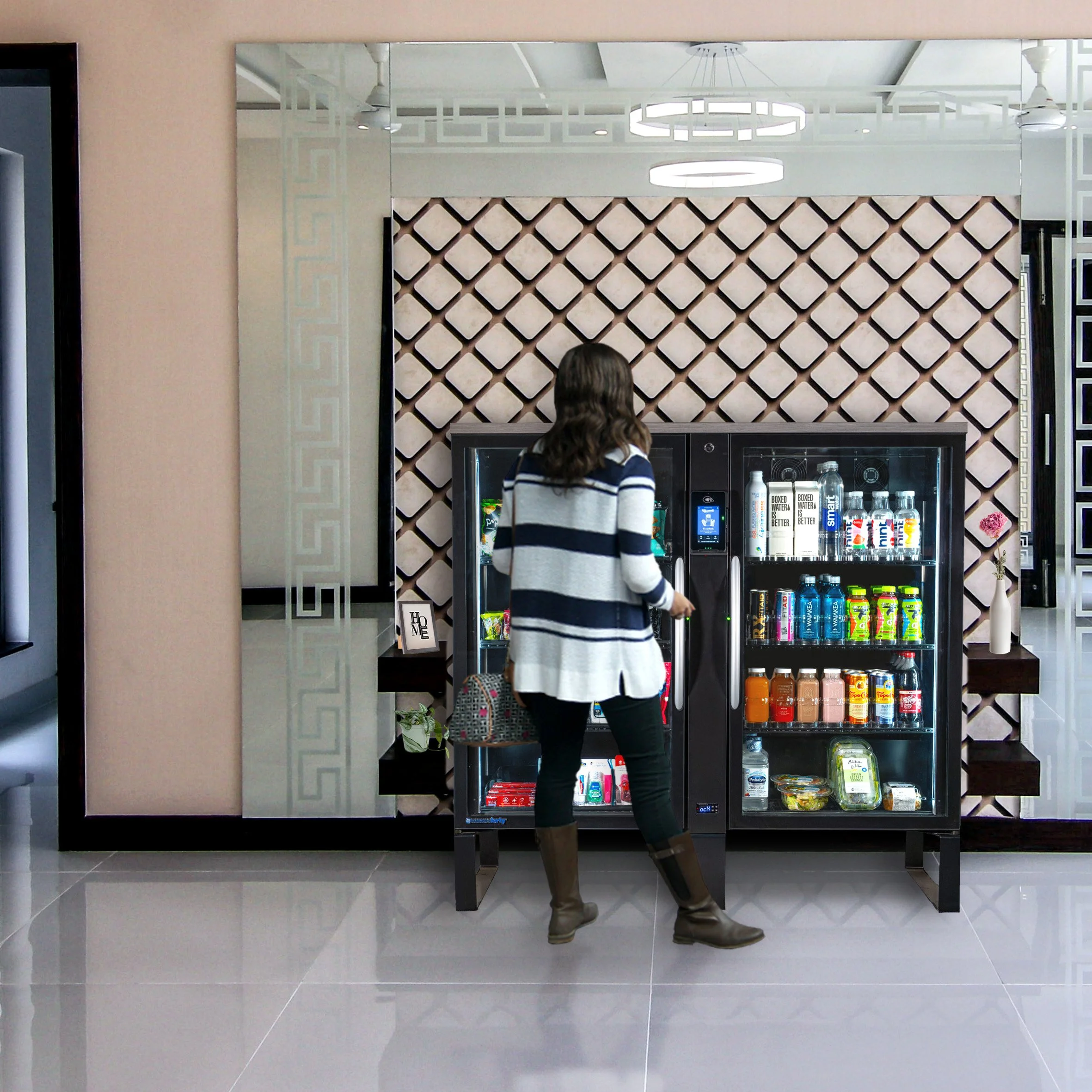 A woman in a striped sweater and rubber boots is selecting a drink from a vending machine in a modern room with decorated walls and ceiling lights.