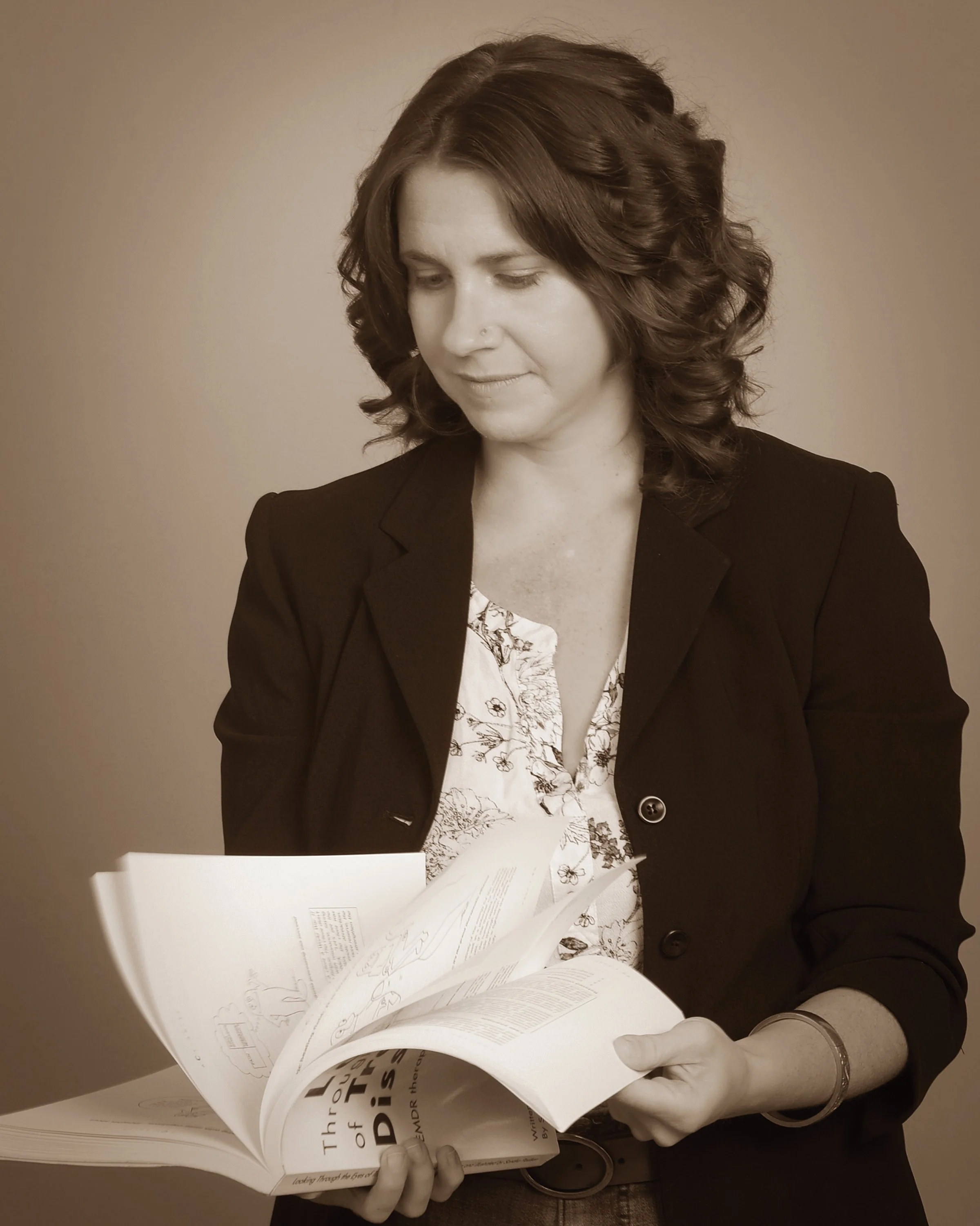 EMDR therapist flipping through a copy of the book Looking Through the Eyes of Trauma and Dissociation